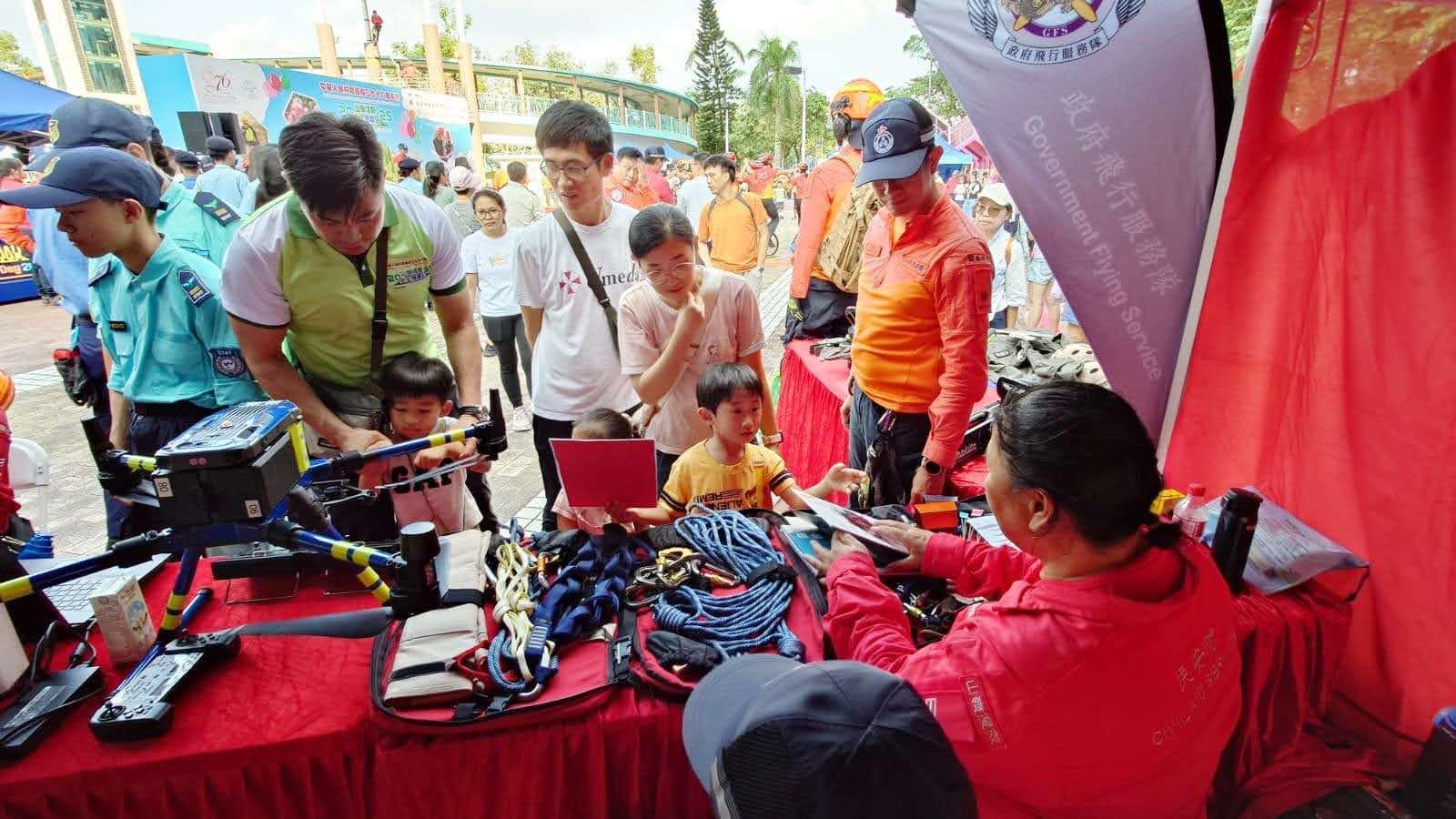 The Civil Aid Service held the 76th Anniversary of the Founding of the People's Republic of China and Mountaineering Safety Promotion Day 2025 with various government departments and mountaineering organisations today (October 19) at Quarry Bay Park. Photo shows members of the public viewing the mountain search and rescue equipment on display at the exhibition.