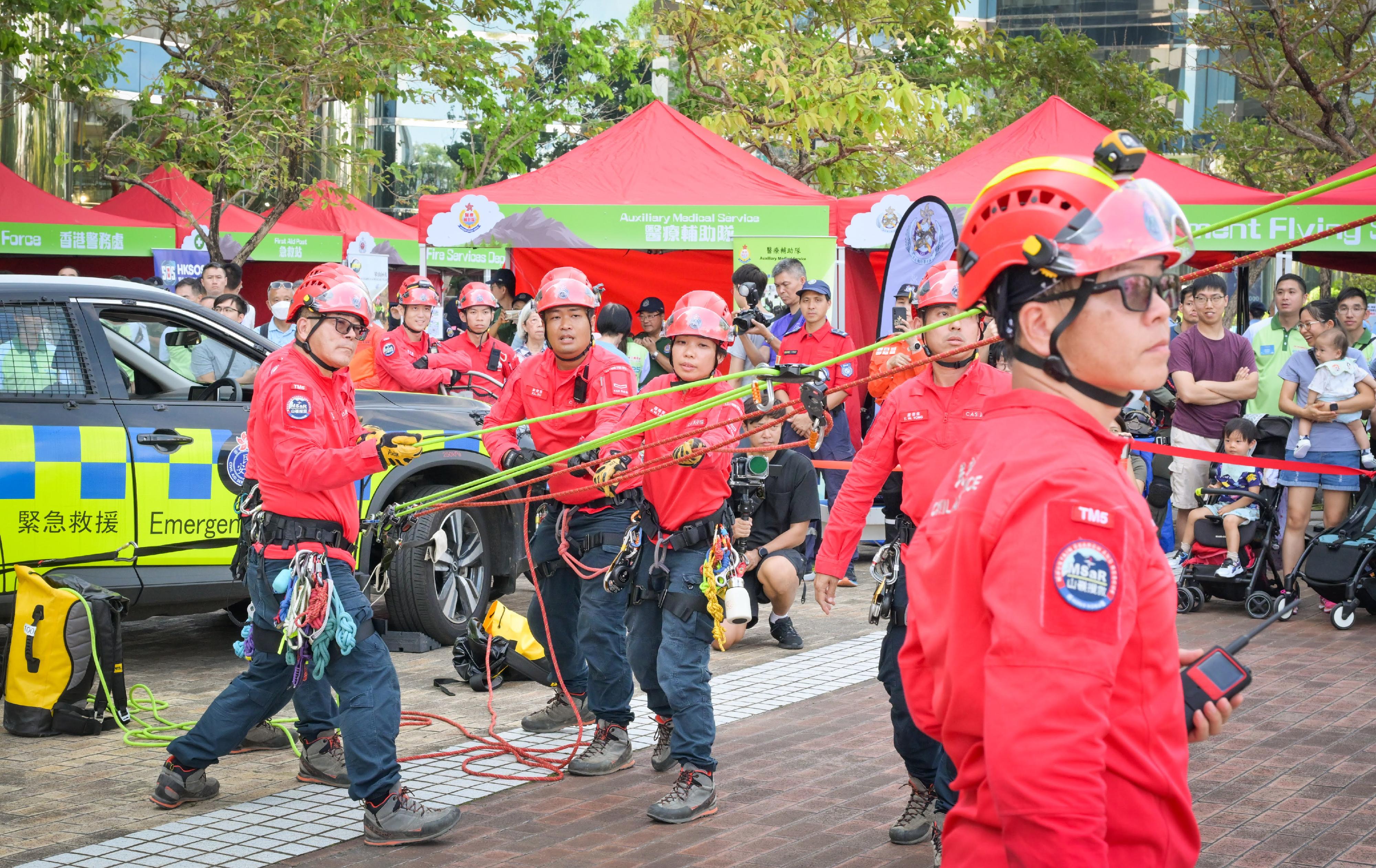 The Civil Aid Service held the 76th Anniversary of the Founding of the People’s Republic of China and Mountaineering Safety Promotion Day 2025 with various government departments and mountaineering organisations today (October 19) at Quarry Bay Park. Photo shows members of the public and rescuers working together to conduct a mountain rescue.