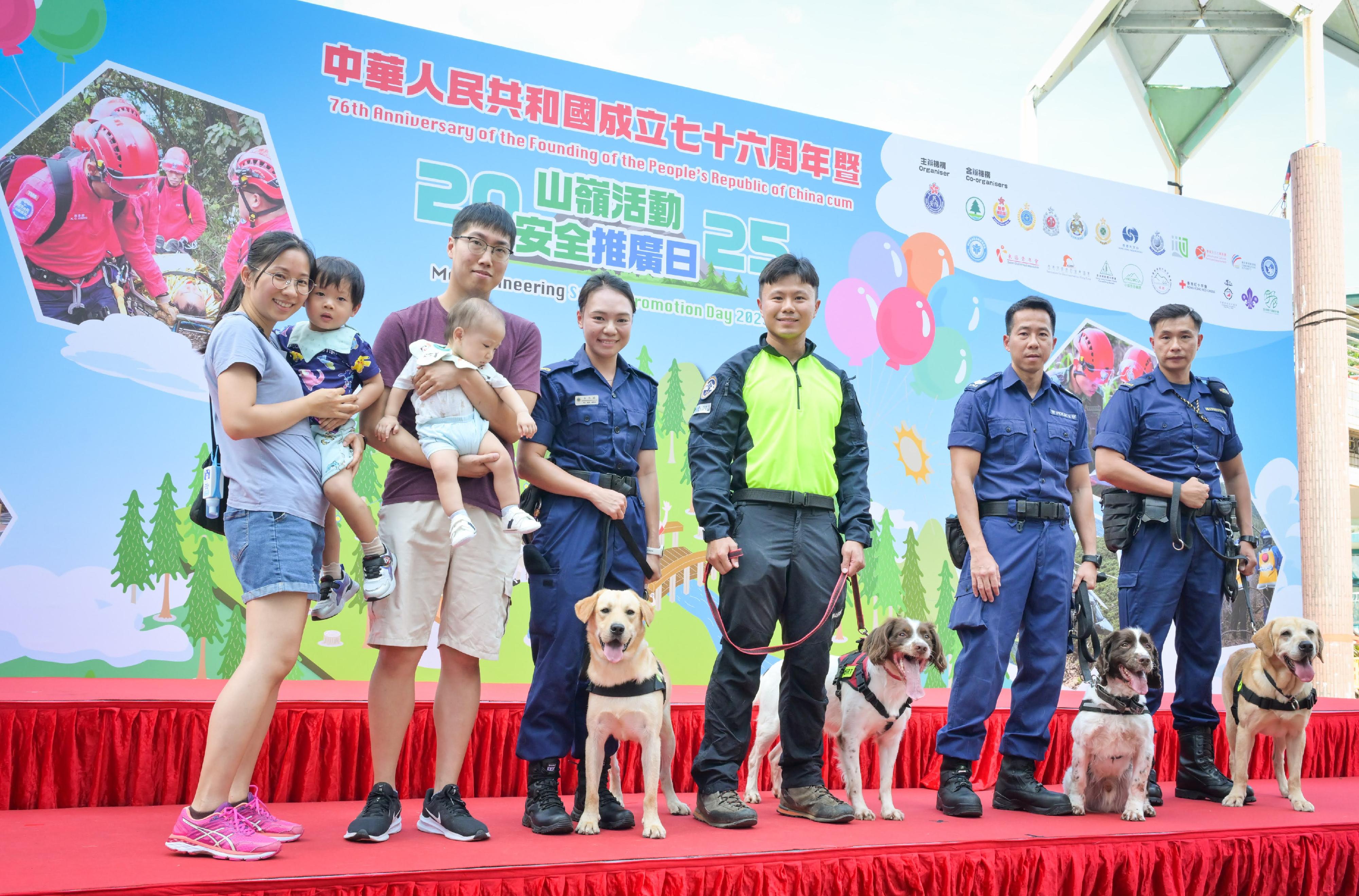 The Civil Aid Service held the 76th Anniversary of the Founding of the People’s Republic of China and Mountaineering Safety Promotion Day 2025 with various government departments and mountaineering organisations today (October 19) at Quarry Bay Park. Photo shows members of the public with working dogs of the disciplined forces.