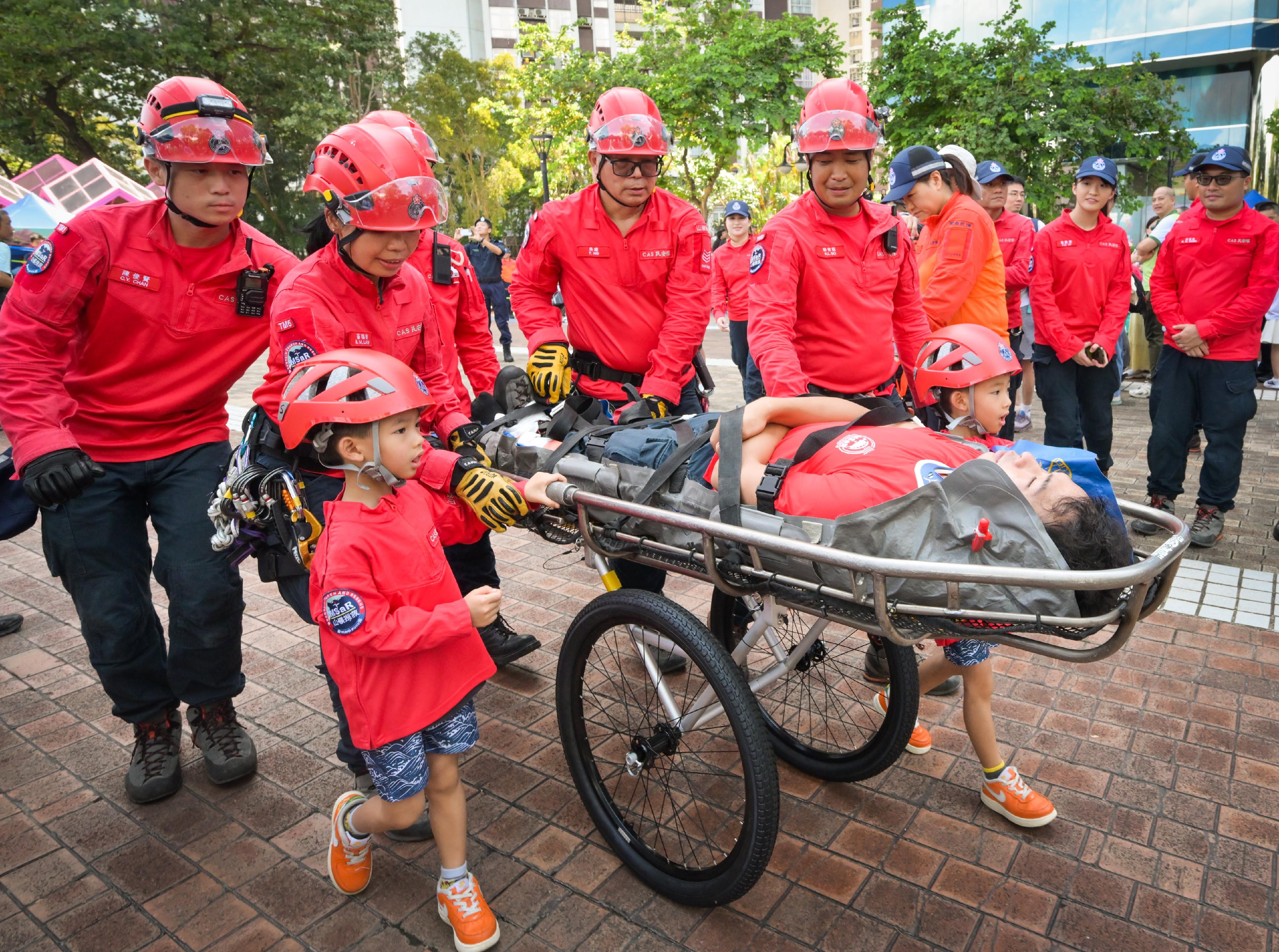 The Civil Aid Service held the 76th Anniversary of the Founding of the People's Republic of China and Mountaineering Safety Promotion Day 2025 with various government departments and mountaineering organisations today (October 19) at Quarry Bay Park. Photo shows CAS members demonstrating technique of mountain search and rescue.