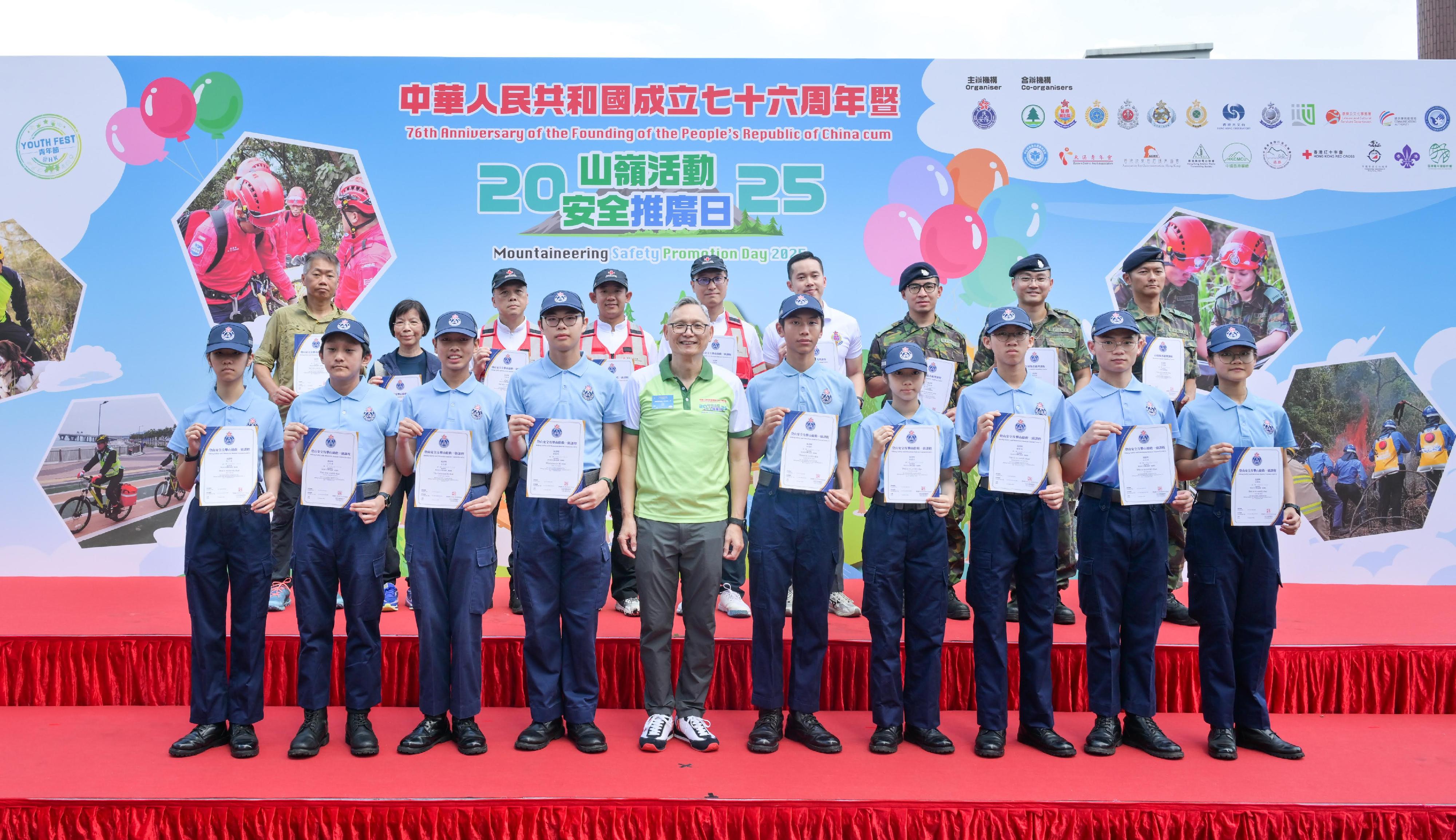 The Civil Aid Service held the 76th Anniversary of the Founding of the People's Republic of China and Mountaineering Safety Promotion Day 2025 with various government departments and mountaineering organisations today (October 19) at Quarry Bay Park. Photo shows the Under Secretary for Security, Mr Michael Cheuk (front row, fifth left), presenting certificates to participants who have successfully completed the Mountain Casualty Handling Course and the Hiking Safety and Mountain Rescue Course.