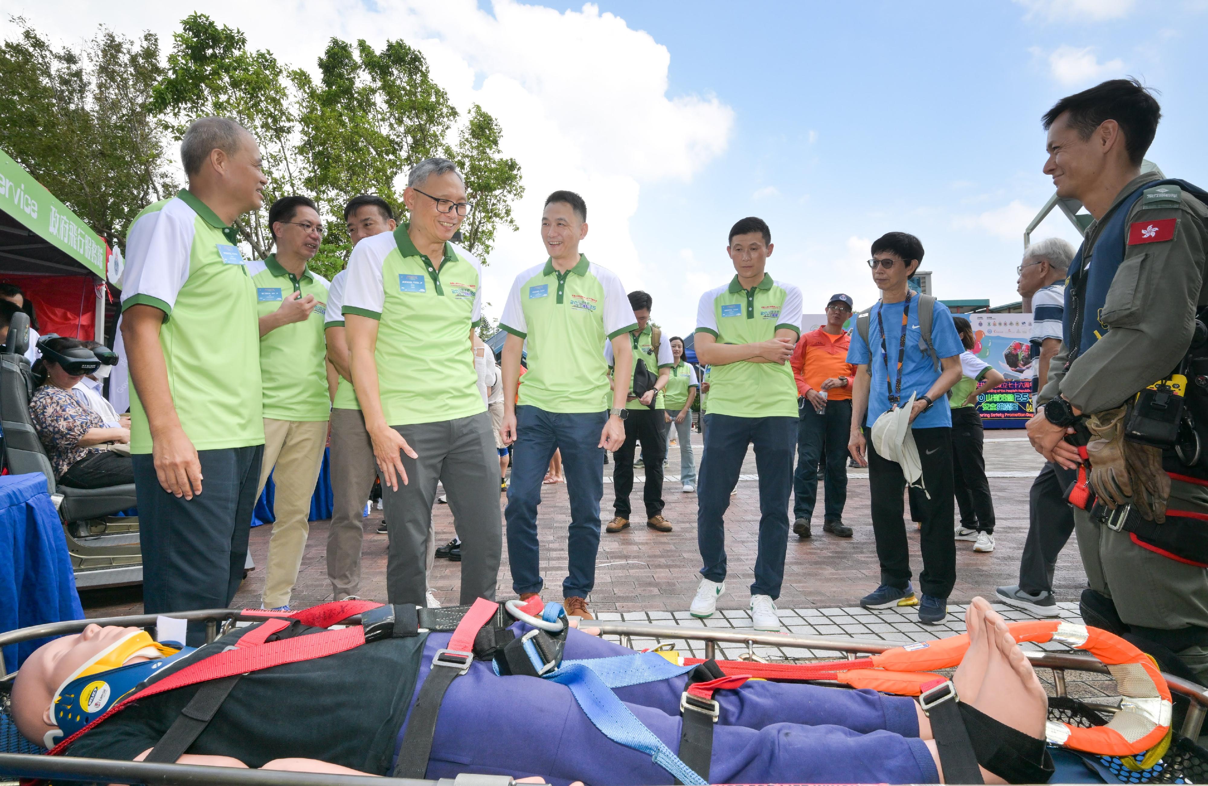 The Civil Aid Service (CAS) held the 76th Anniversary of the Founding of the People's Republic of China and Mountaineering Safety Promotion Day 2025 with various government departments and mountaineering organisations today (October 19) at Quarry Bay Park. Photo shows the Under Secretary for Security, Mr Michael Cheuk (front row, second left), Chief Staff Officer of CAS, Mr Leung Kwun-hong (front row, first left), and other guests visiting an exhibition booth.
