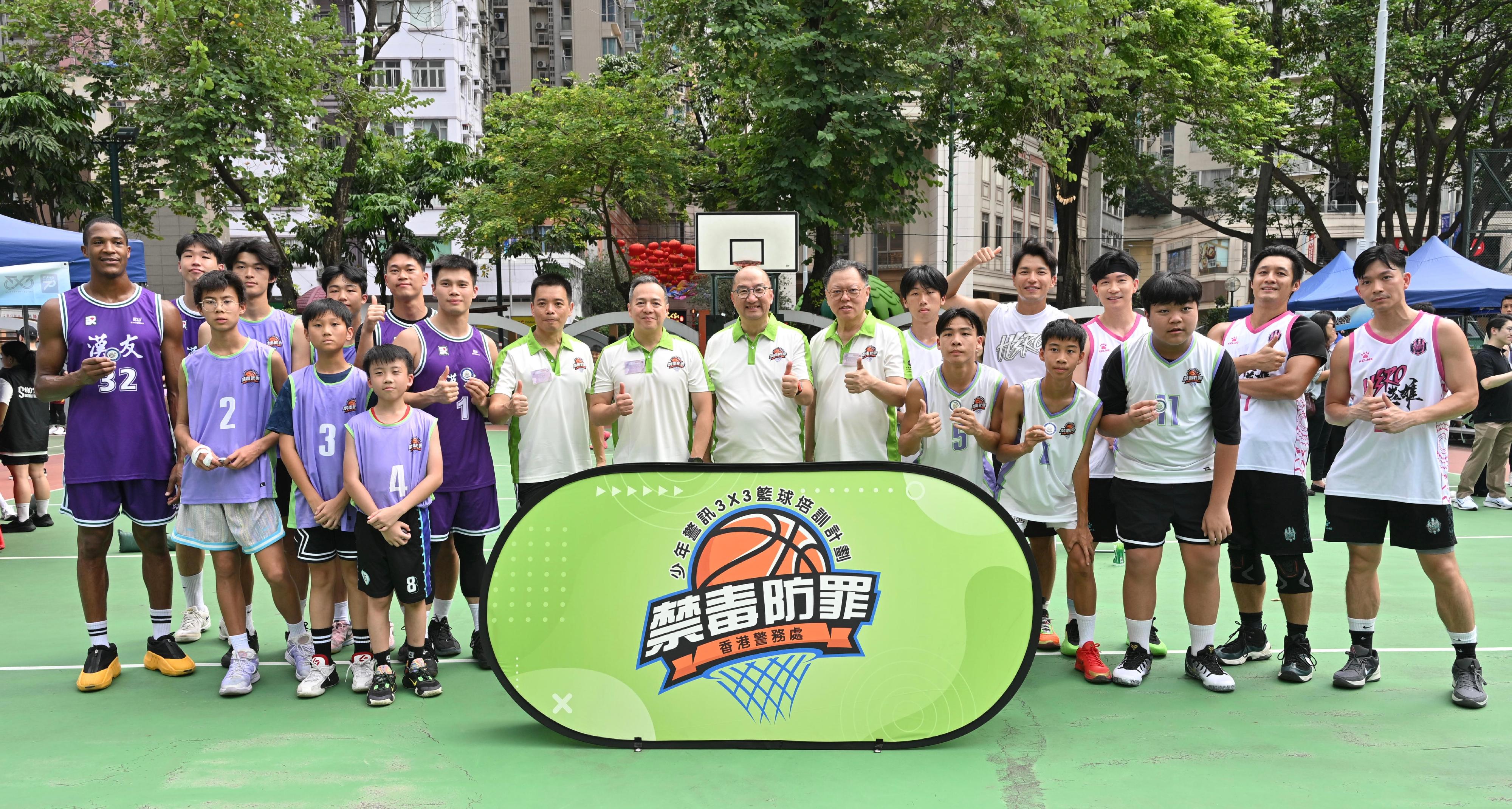 The Hong Kong Police Force today (October 19) held the Junior Police Call Anti-Narcotics and Fight Crime 3x3 Basketball Tournament and Carnival. The Commissioner of Police, Mr Chow Yat-ming (back row, eighth left); the Executive Director, Corporate Affairs of the Hong Kong Jockey Club, Mr Raymond Tam (back row, seventh right); the Chairman of the Teens and Elderly Mission Committee, Mr Tong Tai-kam (back row, sixth right); and the Regional Commander of Hong Kong Island, Mr Au Wing-leung (back row, seventh left), in a photo with the teams participating in the exhibition match.