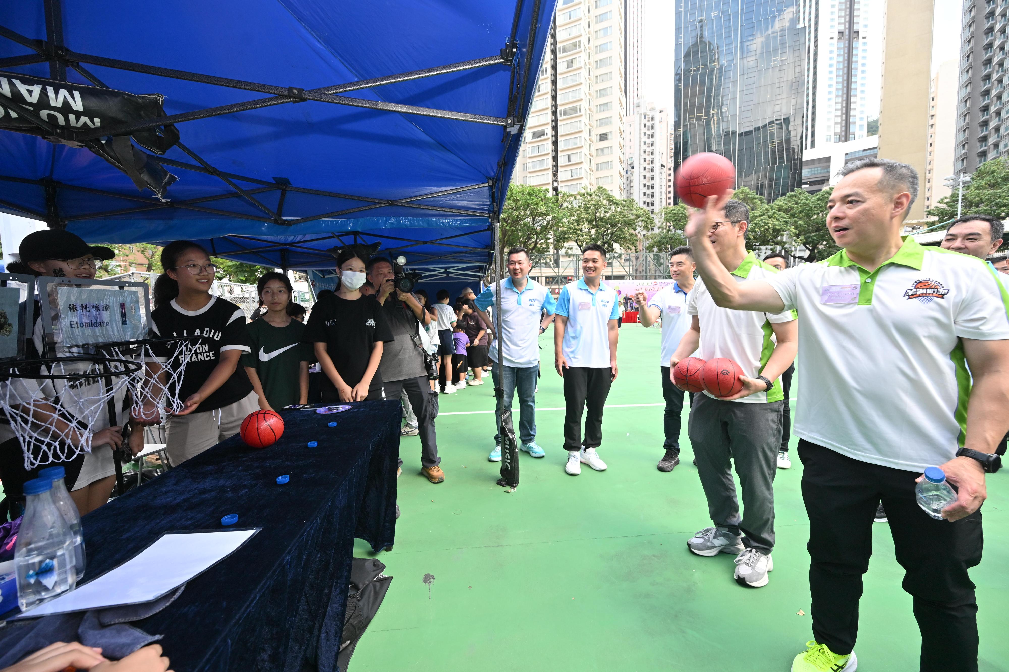 The Hong Kong Police Force today (October 19) held the Junior Police Call Anti-Narcotics and Fight Crime 3x3 Basketball Tournament and Carnival. Photo shows the Commissioner of Police, Mr Chow Yat-ming (first right) participating in an interactive game promoting anti-drug messages.