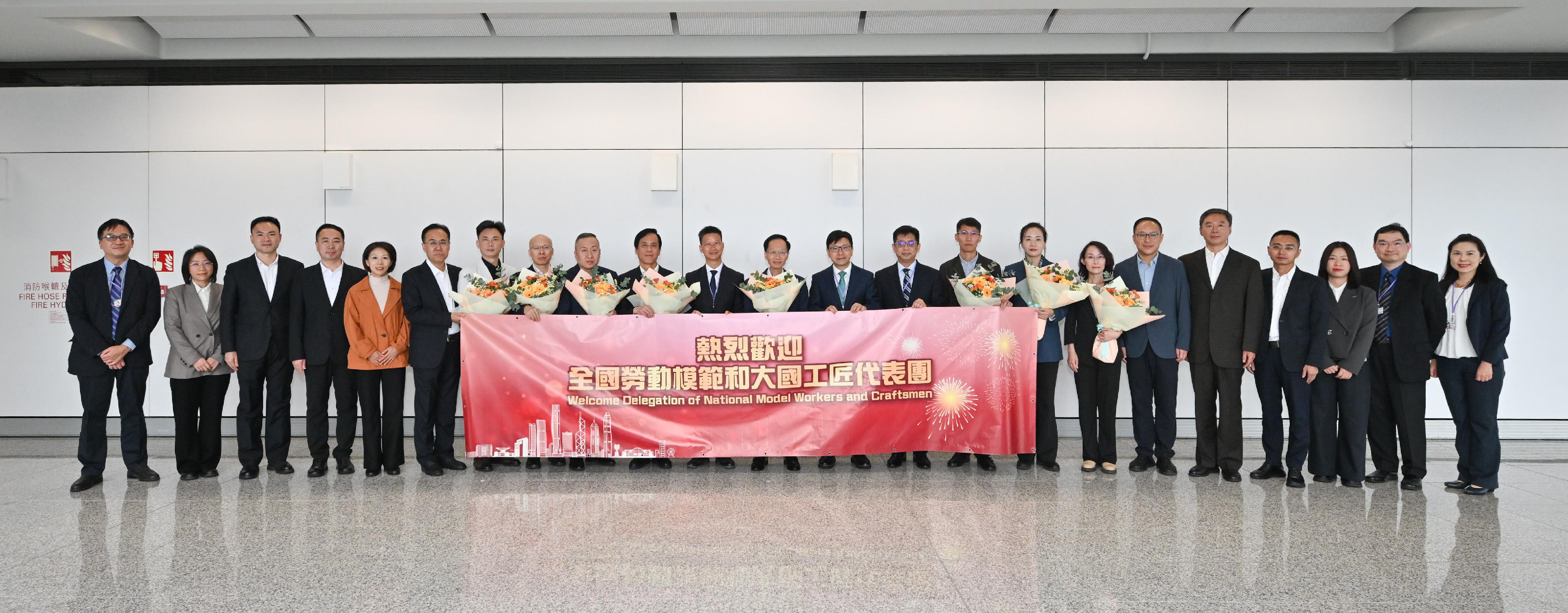全國勞動模範和大國工匠代表團今日（十月二十日）抵港，展開一連四天的訪問活動。圖示勞工及福利局局長孫玉菡（右十一）及勞工處處長許澤森（左十一）與代表團團長、中華全國總工會副主席魏地春（中）、其他代表團成員及歡迎隊伍在香港國際機場合照。 