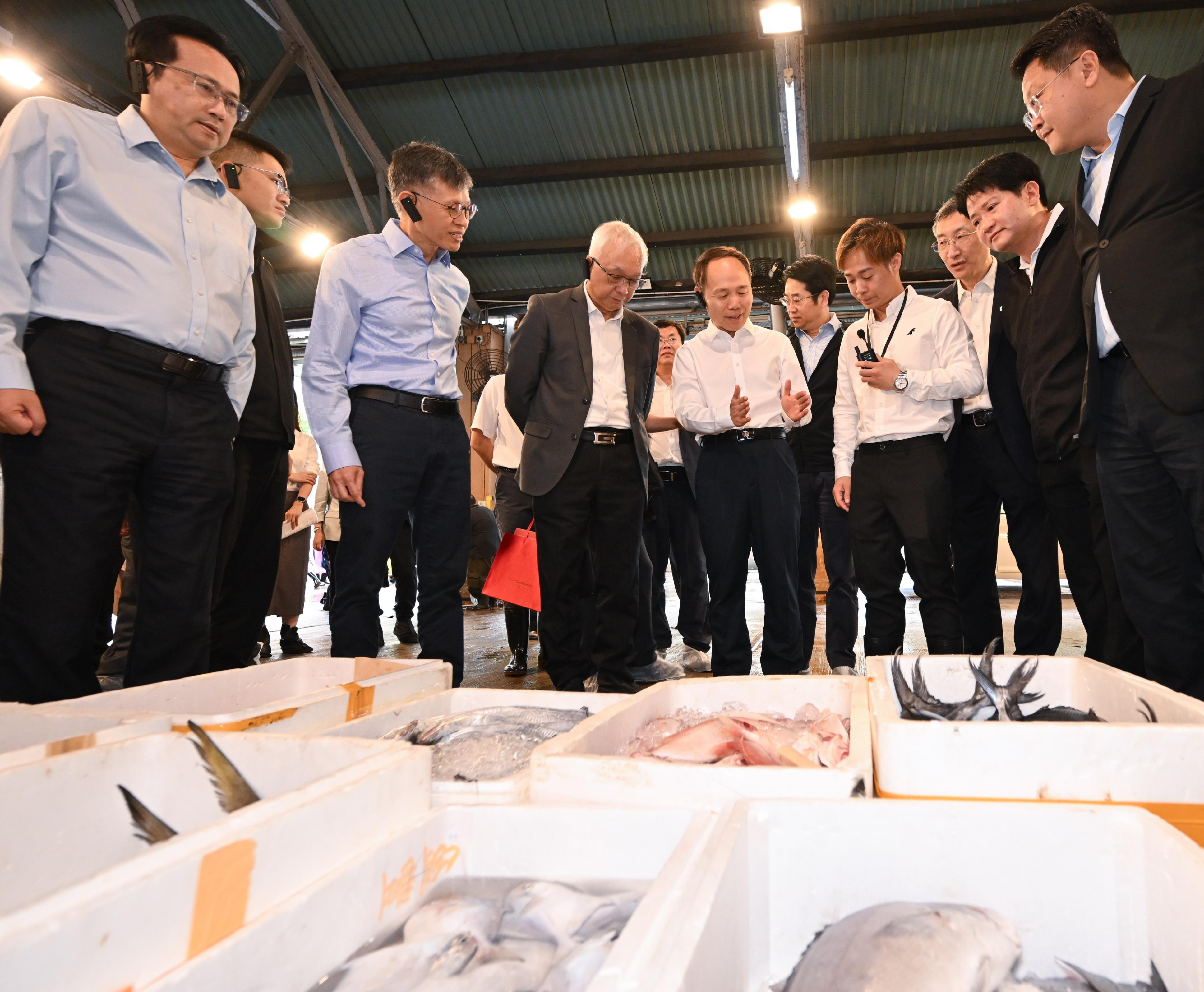 Accompanied by the Secretary for Environment and Ecology, Mr Tse Chin-wan (fourth left), and the Director of Agriculture, Fisheries and Conservation, Mr Mickey Lai (third left), a delegation led by Vice Minister of Agriculture and Rural Affairs Mr Zhang Zhili (fifth left) today (October 21) visited the Aberdeen Wholesale Fish Market under the Fish Marketing Organization to understand the production and wholesale of fisheries products in the Hong Kong Special Administrative Region.