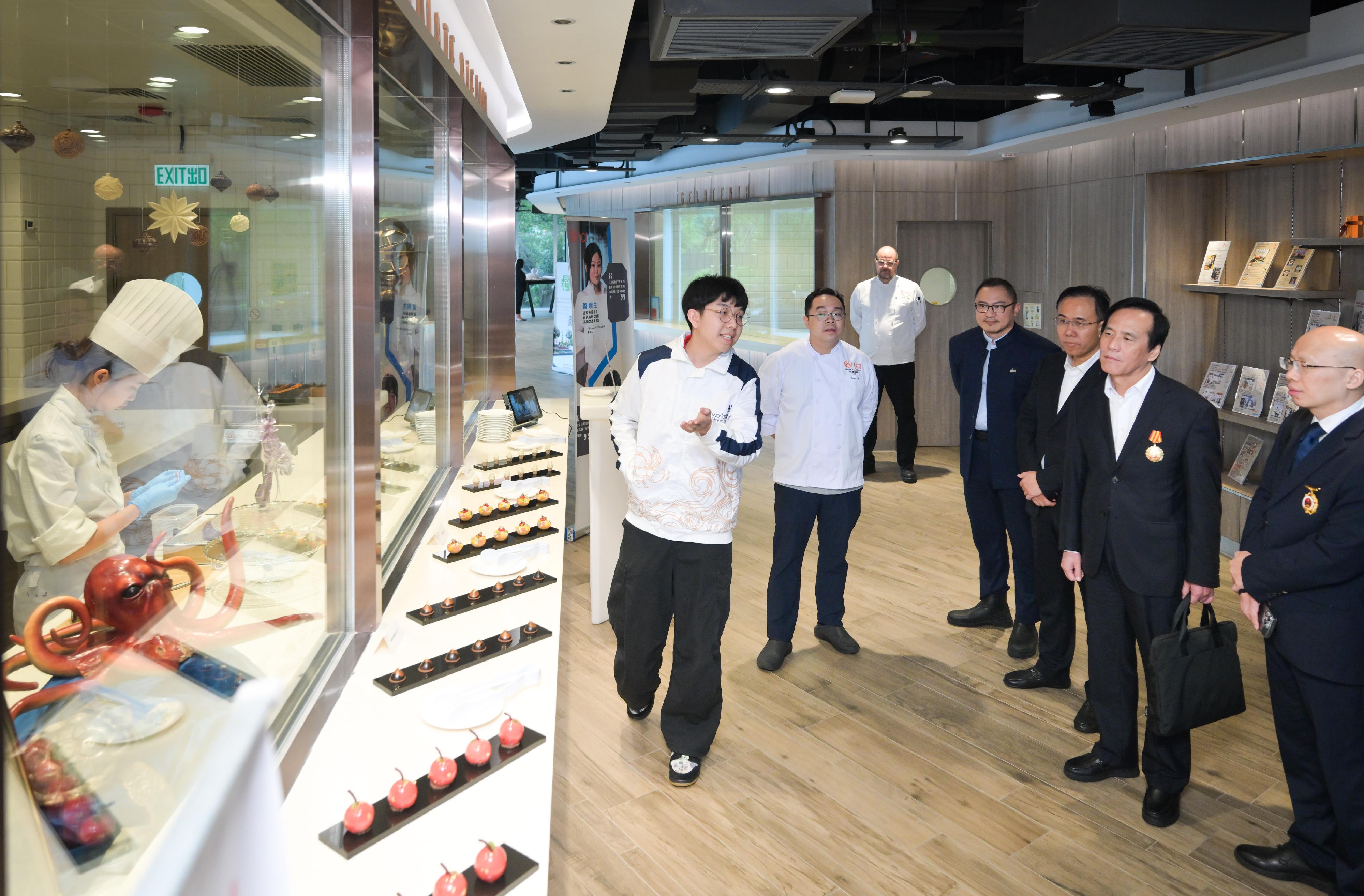The Delegation of National Model Workers and Craftsmen continued its visit to Hong Kong today (October 21), exchanging views and interacting with major local labour organisations, employees and representatives from various sectors. Photo shows members of the delegation visiting the International Culinary Institute under the Vocational Training Council and watching a culinary demonstration.