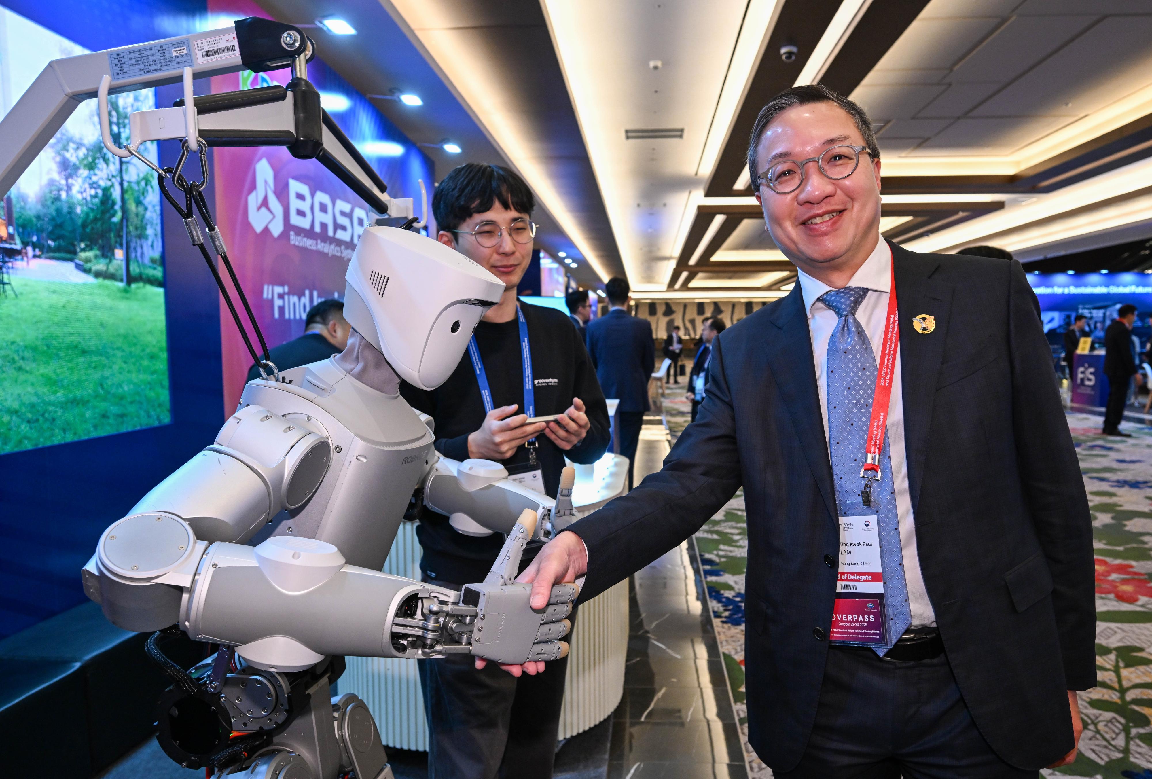 The Secretary for Justice, Mr Paul Lam, SC, attended the 2025 Asia-Pacific Economic Cooperation Structural Reform Ministerial Meeting in Incheon, Korea, today (October 22). Photo shows Mr Lam (right) touring the exhibition at the meeting venue.