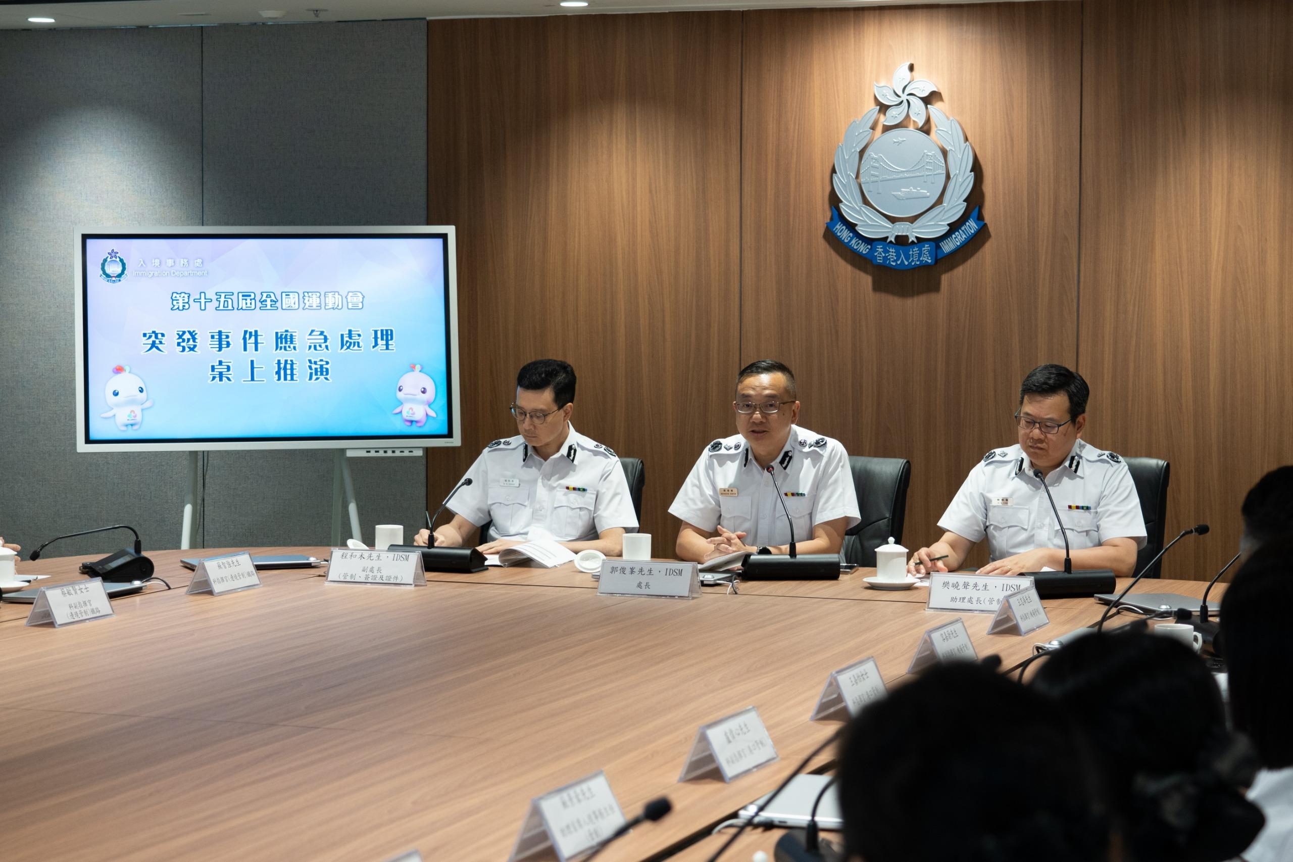 The Immigration Department conducted a tabletop exercise yesterday (October 21) to rehearse the handling of emergency incidents during the 15th National Games. Photo shows the Director of Immigration, Mr Benson Kwok (centre); the Deputy Director (Control, Visa and Documents), Mr Ching Wo-mok (left); and the Assistant Director (Control), Mr Fan Hiu-sing (right), receiving a briefing from officers and giving advice.