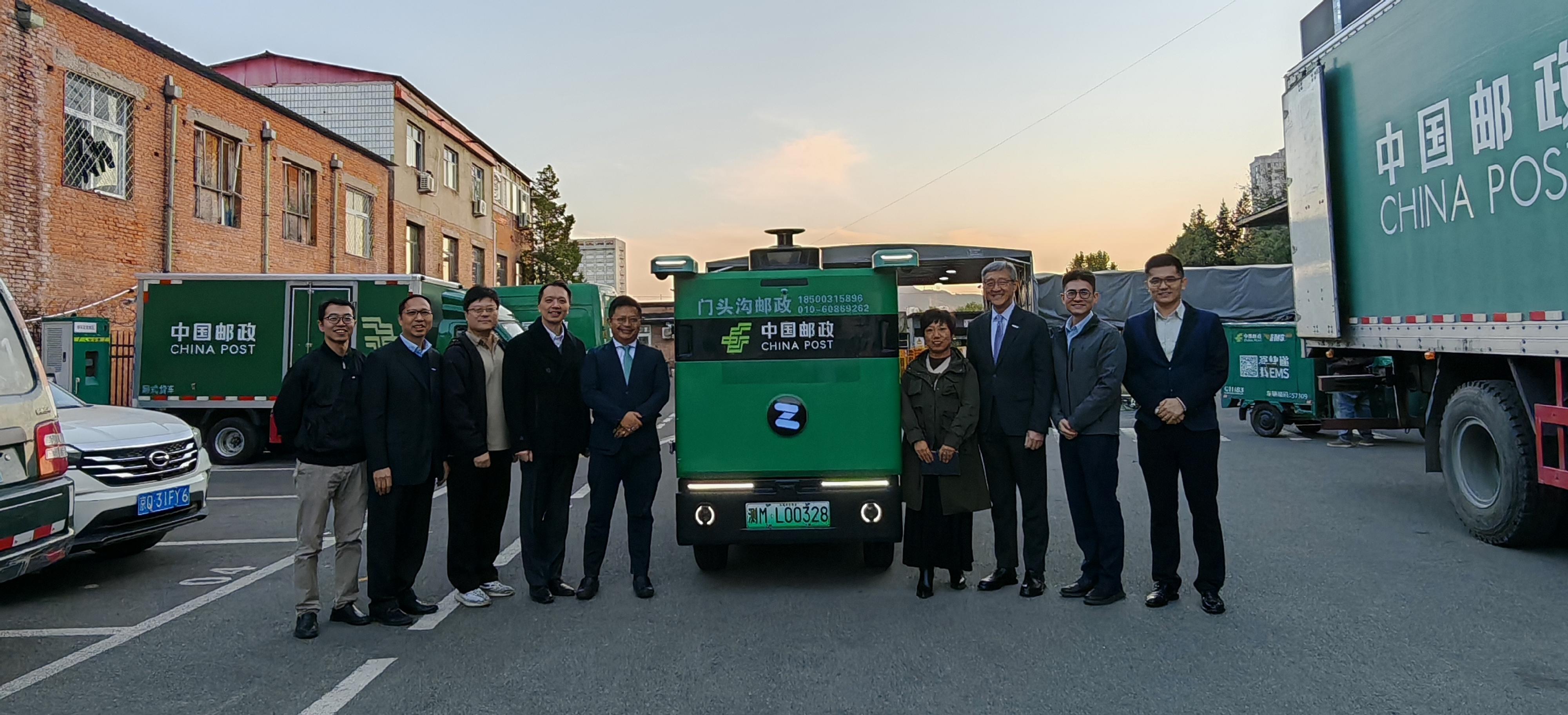 引進重點企業辦公室（引進辦）主任任景信聯同團隊十月十九至二十二日訪問北京。圖示任景信（右三）及引進辦執行總裁彭文俊（左四）參觀一家自動駕駛技術企業於北京門頭溝郵政局的實地應用場景。