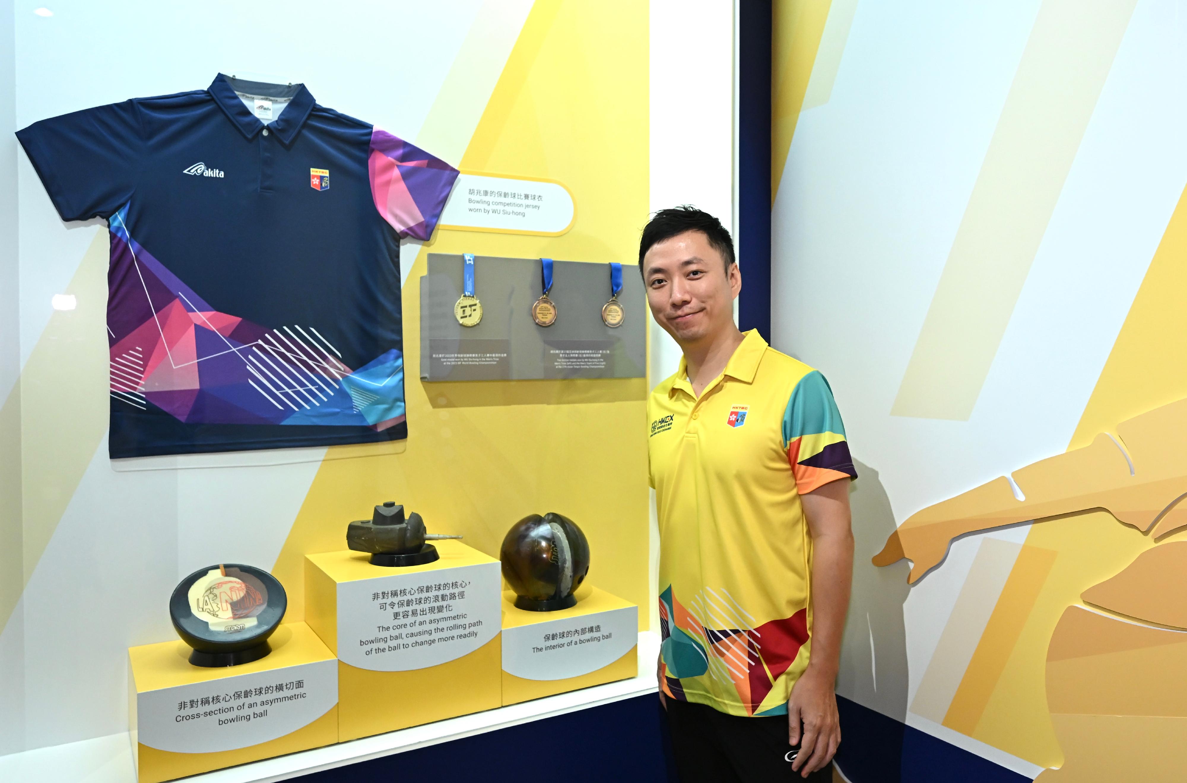 In support of the 2025 National Games, the Hong Kong Science Museum will launch the "Bank of China (Hong Kong) Presents: National Development and Achievements Series - Approaching Perfection: The Intersection of Sports and Science" exhibition from tomorrow (October 24) to February 25 next year. Photo shows tenpin bowling athlete Wu Siu-hong, with his competition jersey and the gold medal he won in the Men's Trios at the 2023 IBF World Bowling Championships, at the exhibition. 