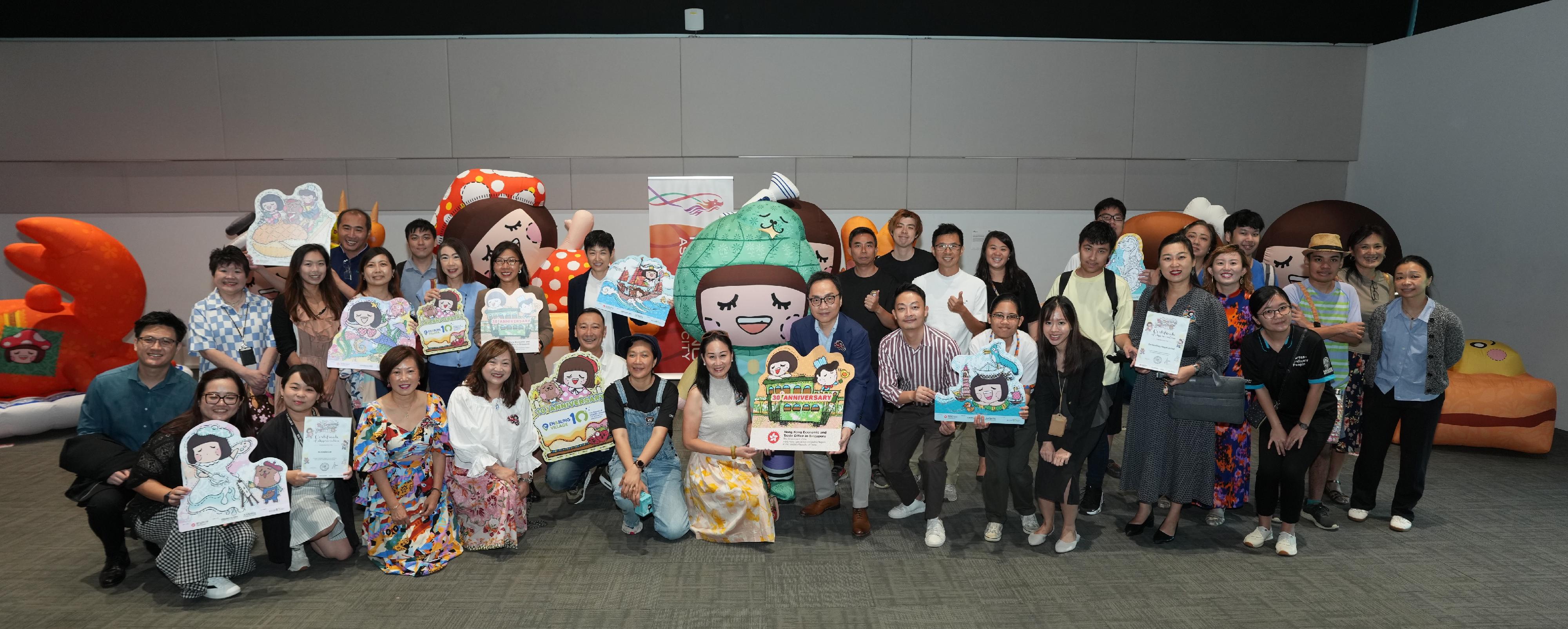 香港駐新加坡經濟貿易辦事處（駐新加坡經貿辦）與香港知名創作品牌 Chocolate Rain於今日（十月二十三日）至十月二十六日，共同在新加坡新協立綜合設施舉辦社區藝術展。這場繽紛多彩的展覽歡迎不同藝術愛好者參觀，藉此促進香港與新加坡之間的文化交流。圖示駐新加坡經貿辦處長馮浩然（第一排右四）、Chocolate Rain創辦人麥雅端（第一排右六），與多名社區藝術展參觀者合照。