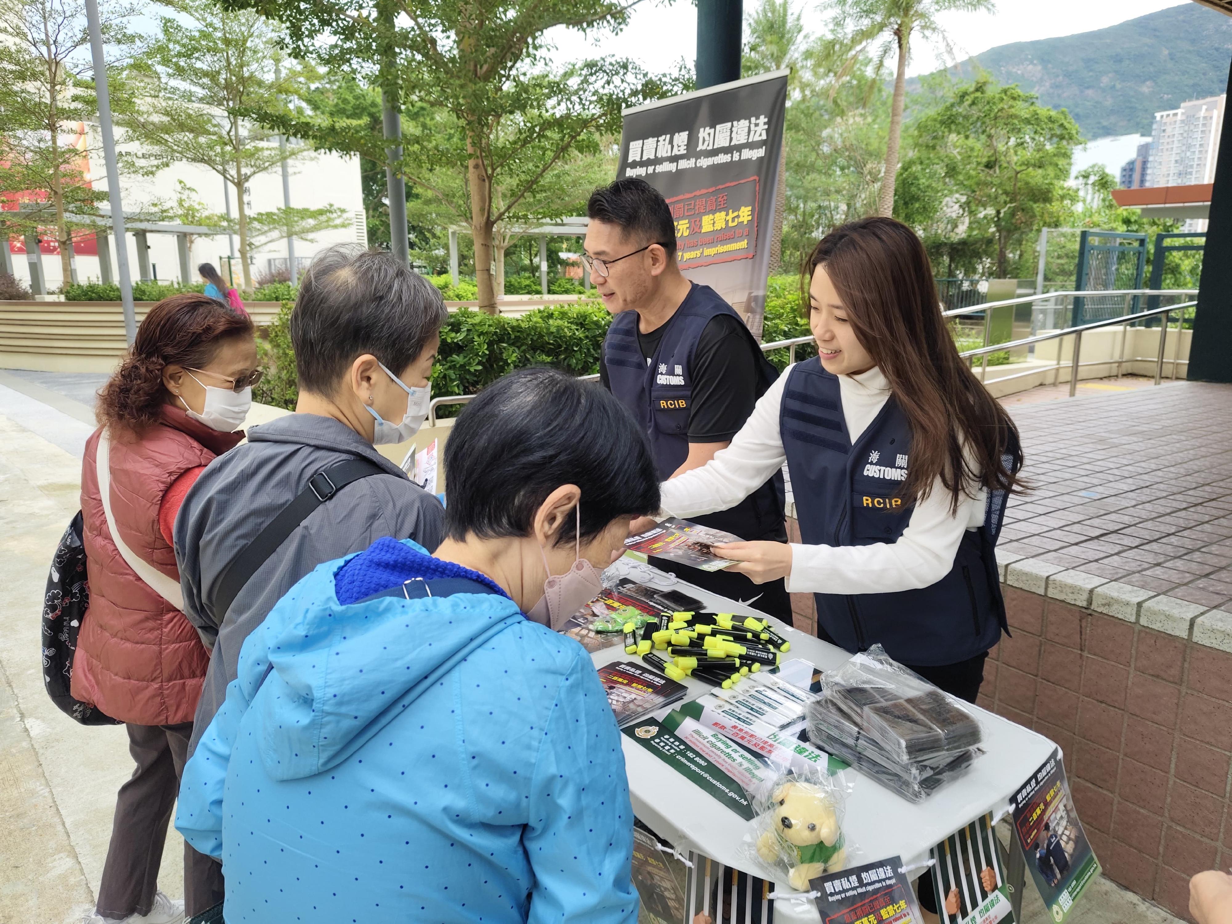  香港海關今日（十月二十三日）與南區區議員、衞生署控煙酒辦公室及房屋署在南區鴨脷洲邨進行聯合反私煙宣傳活動。圖示海關人員向居民介紹海關打擊私煙的工作及私煙相關法例的最新修訂。