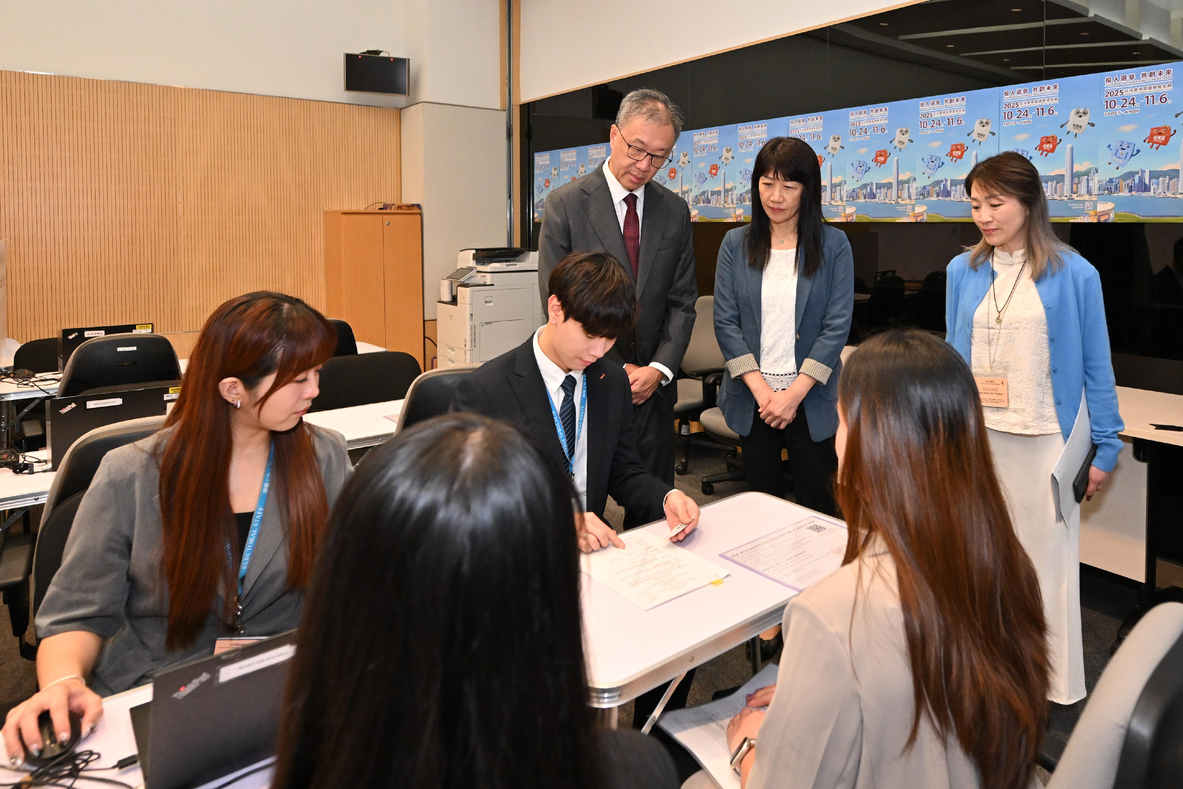 選舉管理委員會主席陸啟康法官今日（十月二十三日）到訪位於添馬政府總部接收二○二五年立法會換屆選舉提名表格的選舉主任辦事處。圖示陸啟康法官（後排左）在選舉事務處總選舉事務主任陳淑華（後排中）陪同下，了解接收提名表格的流程。