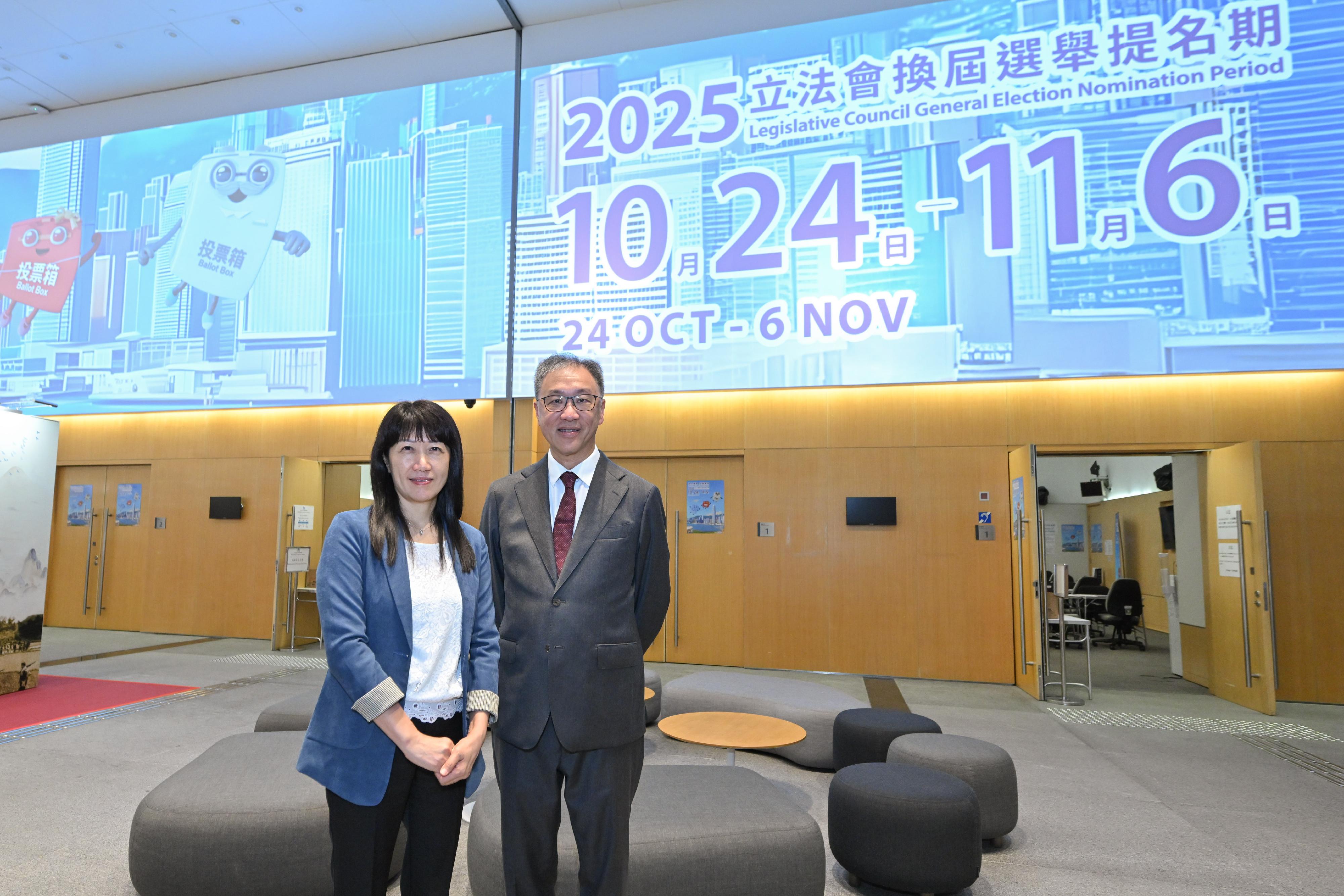 The Chairman of the Electoral Affairs Commission, Mr Justice David Lok, today (October 23) visited the Returning Officer's office at the Central Government Offices (CGO), Tamar, where nomination forms for the 2025 Legislative Council General Election (LCGE) will be received. Photo shows Mr Justice Lok (right) and the Chief Electoral Officer of the Registration and Electoral Office, Ms Natalie Chan (left), with the giant digital promotional banner of the 2025 LCGE at the CGO.