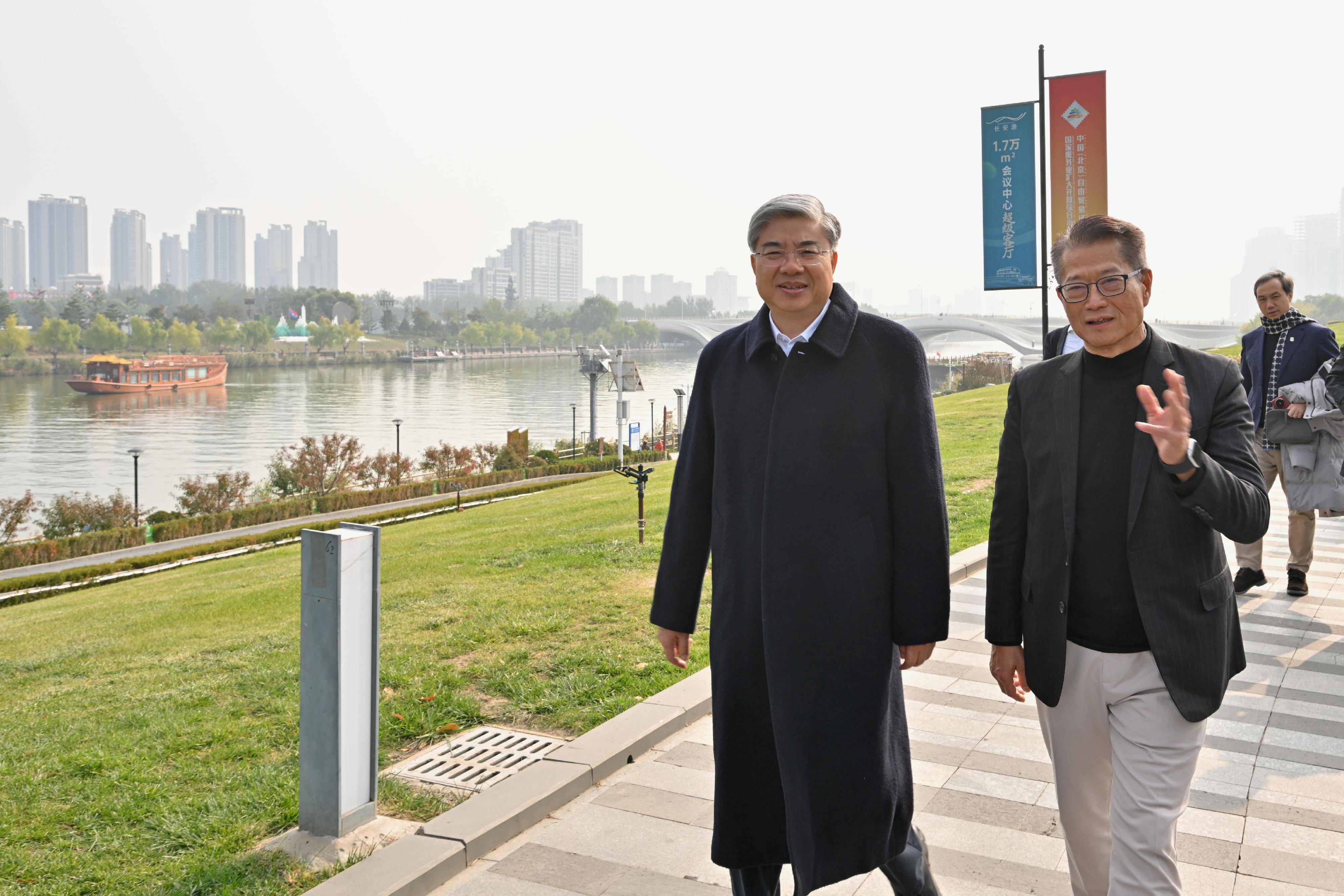 財政司司長陳茂波今日（十月二十三日）率領香港特別行政區代表團訪問北京城市副中心和河北雄安新區。圖示陳茂波（右）在北京市政府黨組成員、副市長唐文弘（左）陪同下參觀運河商務區。