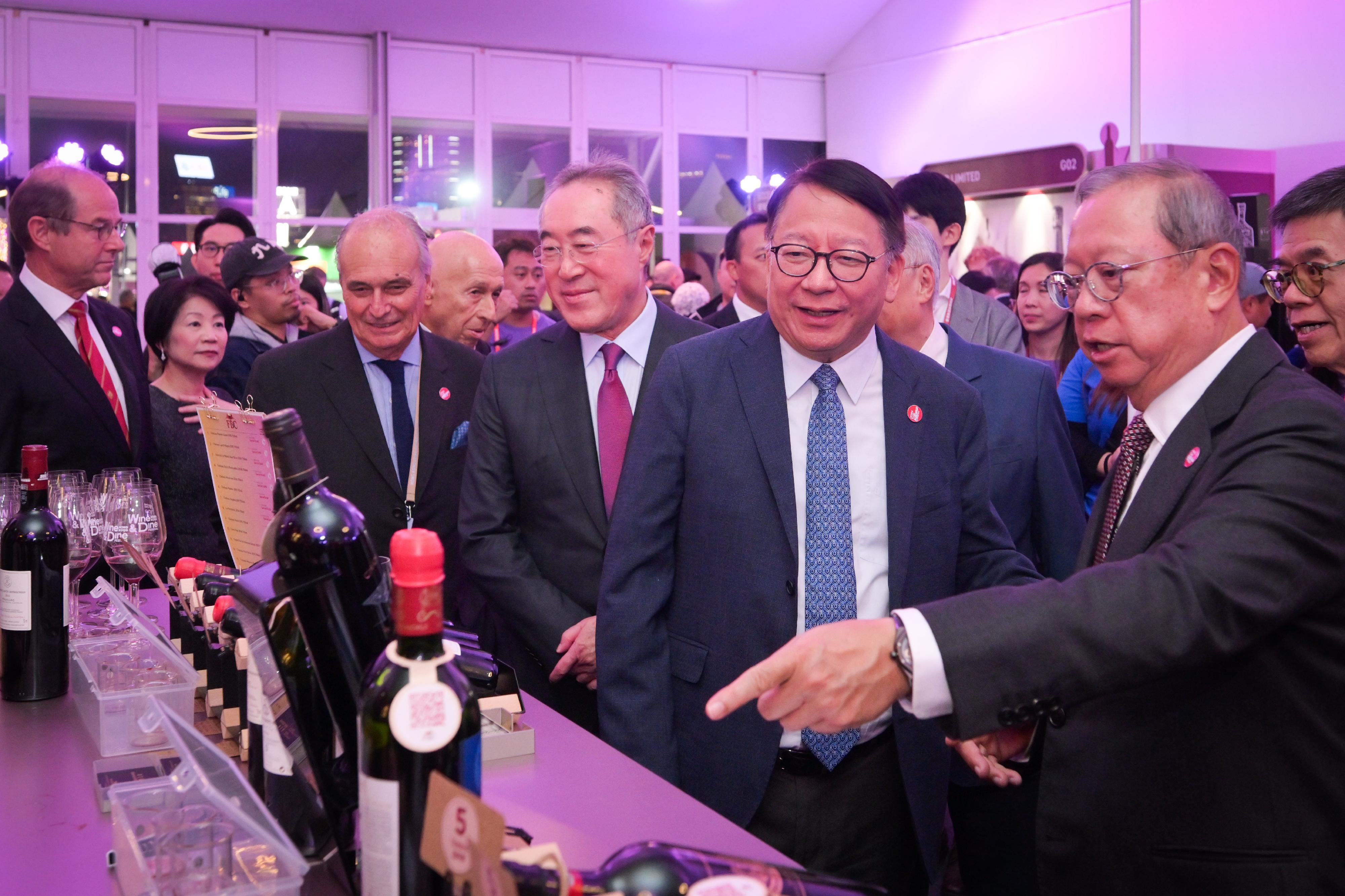 The Chief Secretary for Administration, Mr Chan Kwok-ki, attended the 2025 Hong Kong Wine & Dine Festival opening ceremony today (October 23). Photo shows Mr Chan (second right) visiting an exhibition booth. Looking on is the Chairman of the Hong Kong Trade Development Council, Dr Peter Lam (first right).