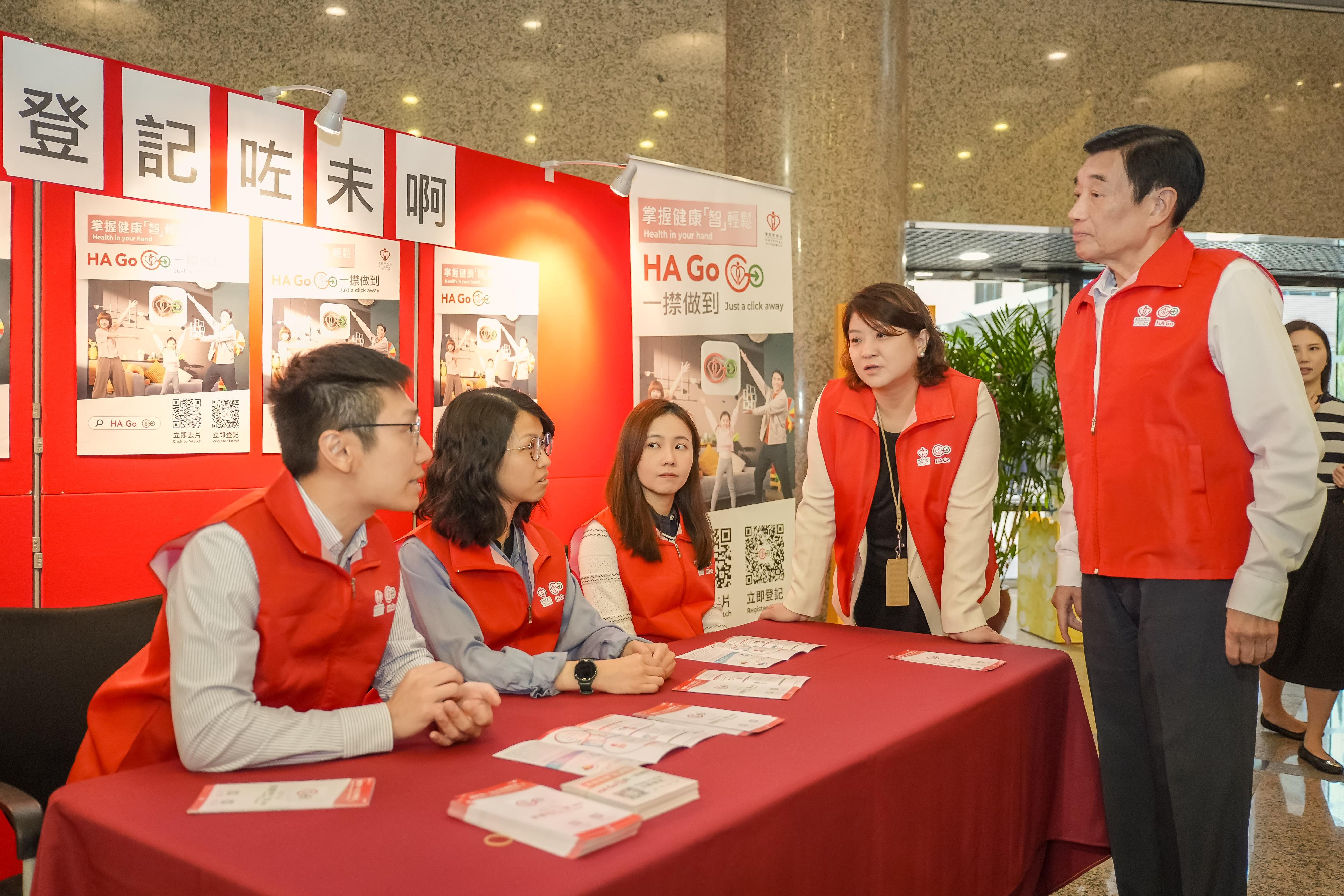 醫院管理局(醫管局)將展開一連三星期的大型推廣活動,鼓勵市民下載及使用醫管局流動應用程式HA Go。圖示醫管局主席范鴻齡(右一)及行政總裁李夏茵醫生(右二)向義工了解宣傳HA Go的工作。