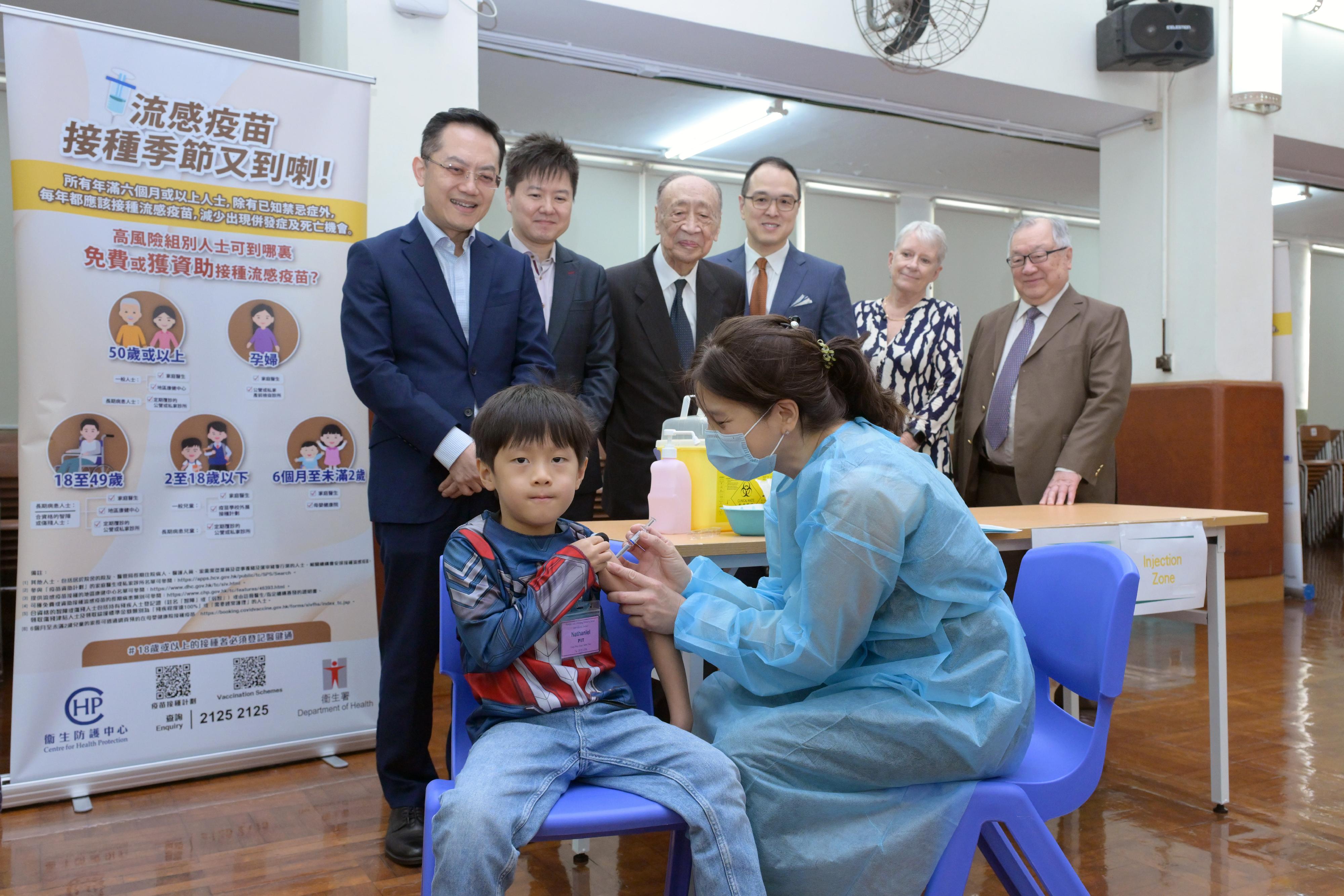 衞生署署長林文健醫生今日(十月二十八日)上午到北角蘇浙小學(國際部),視察季節性流感疫苗學校外展接種的安排,同時呼籲學校盡早完成疫苗接種活動,為家長提供便利,合力提高接種率,減低學童因感染季節性流感而出現重症或死亡的風險。圖示林文健醫生(後排左一)及衞生署衞生防護中心總監徐樂堅醫生(後排左二)在學校代表陪同下視察學生接種注射式滅活流感疫苗。