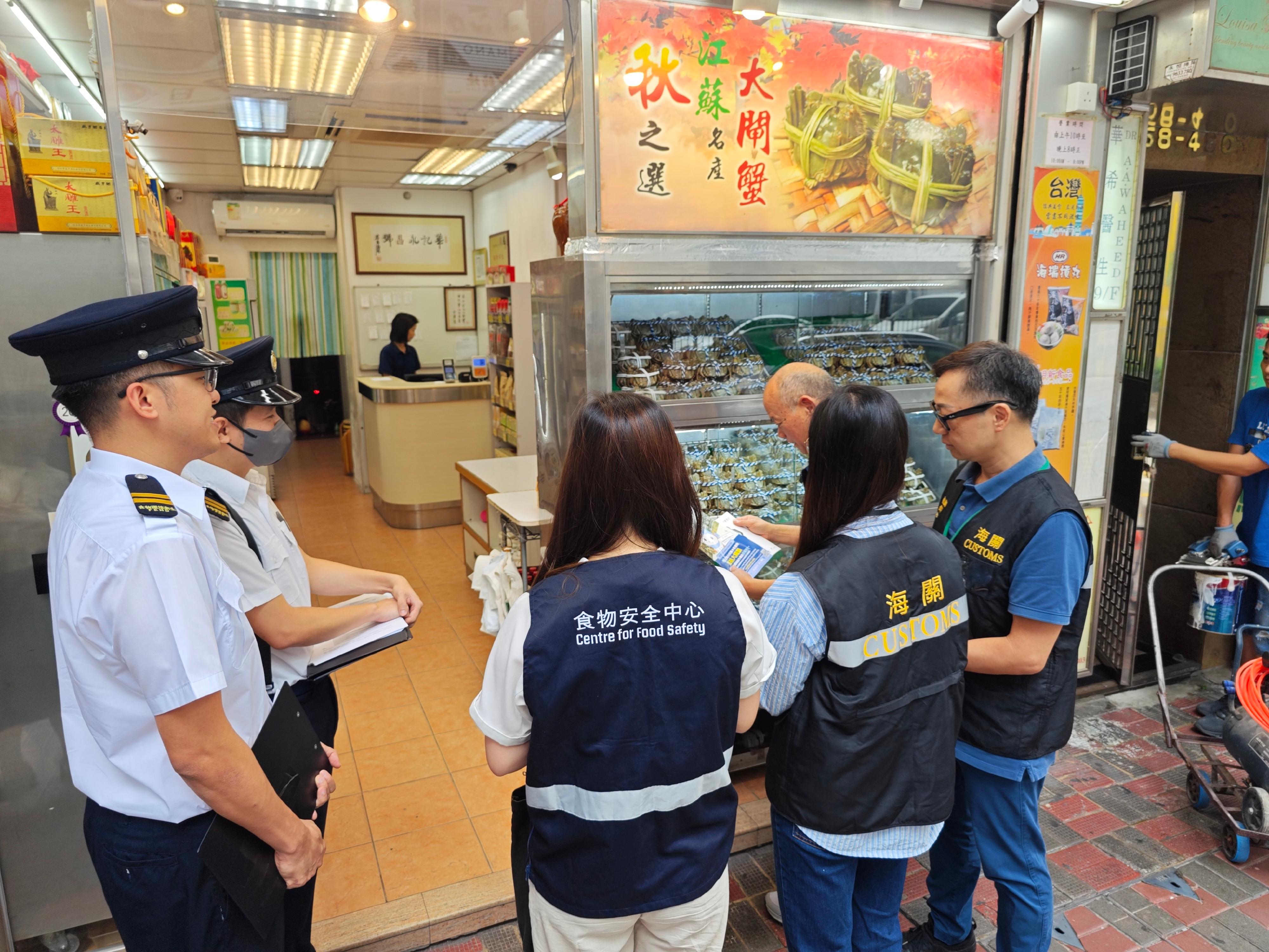 Hong Kong Customs and the Centre for Food Safety and the Environmental Hygiene Branch of the Food and Environmental Hygiene Department (FEHD) have been carrying out joint enforcement operations since Monday (October 27) to inspect hairy crab retail outlets in various districts, with the aim of protecting consumer rights and upholding food safety by ensuring hairy crabs on sale in the market comply with relevant stipulations and requirements under the laws. Photo shows Customs officers and FEHD officers inspecting a retail shop selling hairy crabs and distributing relevant promotional leaflets.