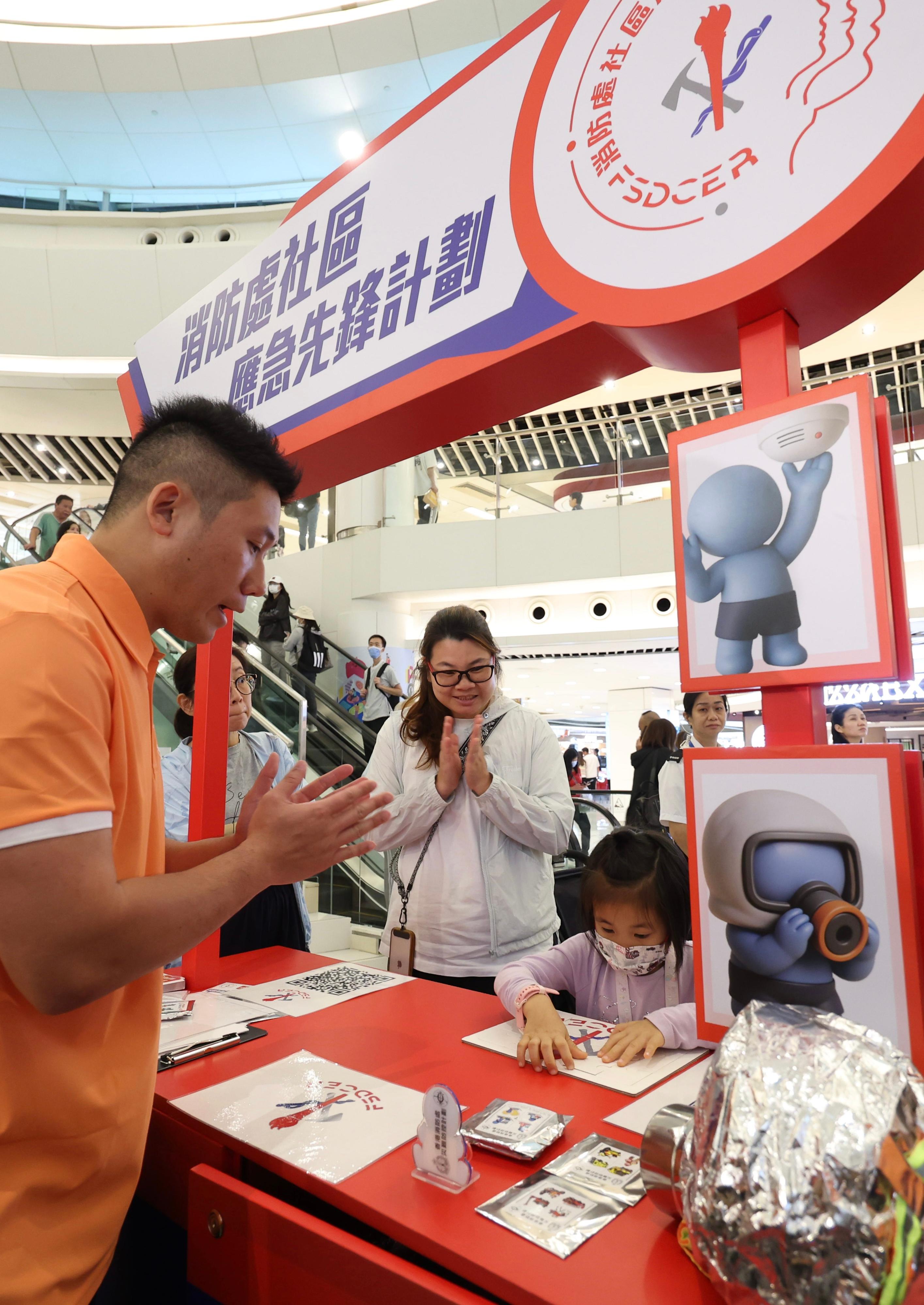 The Fire Services Department (FSD) held the Winter Disaster and Emergency Preparedness Promotional Months launching ceremony and Fire Services Department Community Emergency Responder (FSDCER) award ceremony at New Town Plaza in Sha Tin today (November 1). Photo shows an FSD personnel briefing members of the public on the FSDCER scheme.