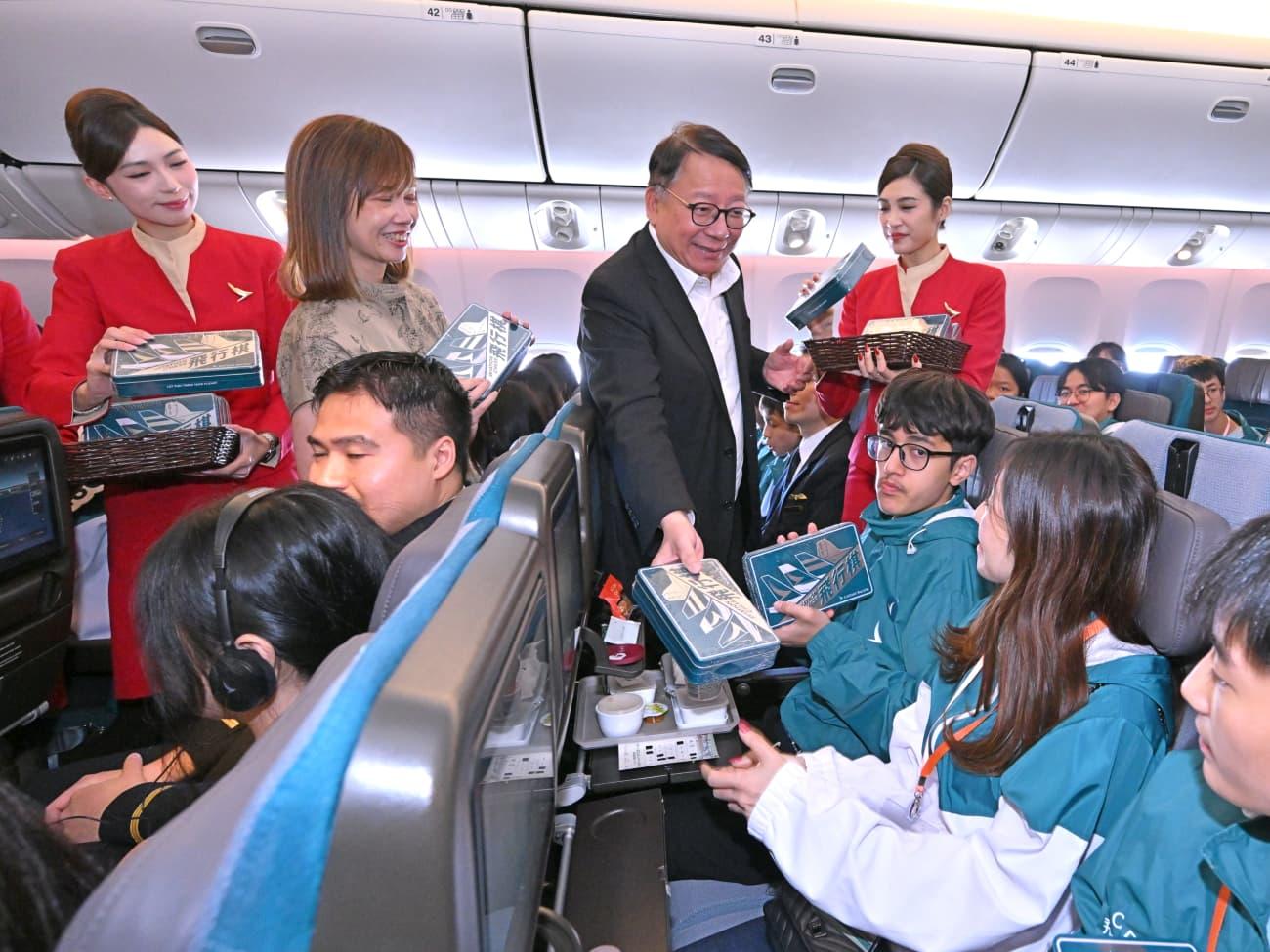 政務司司長陳國基今日（十一月一日）出席國泰飛躍理想計劃——空中之旅2025。圖示陳國基向計劃的友師和學員派發紀念品。