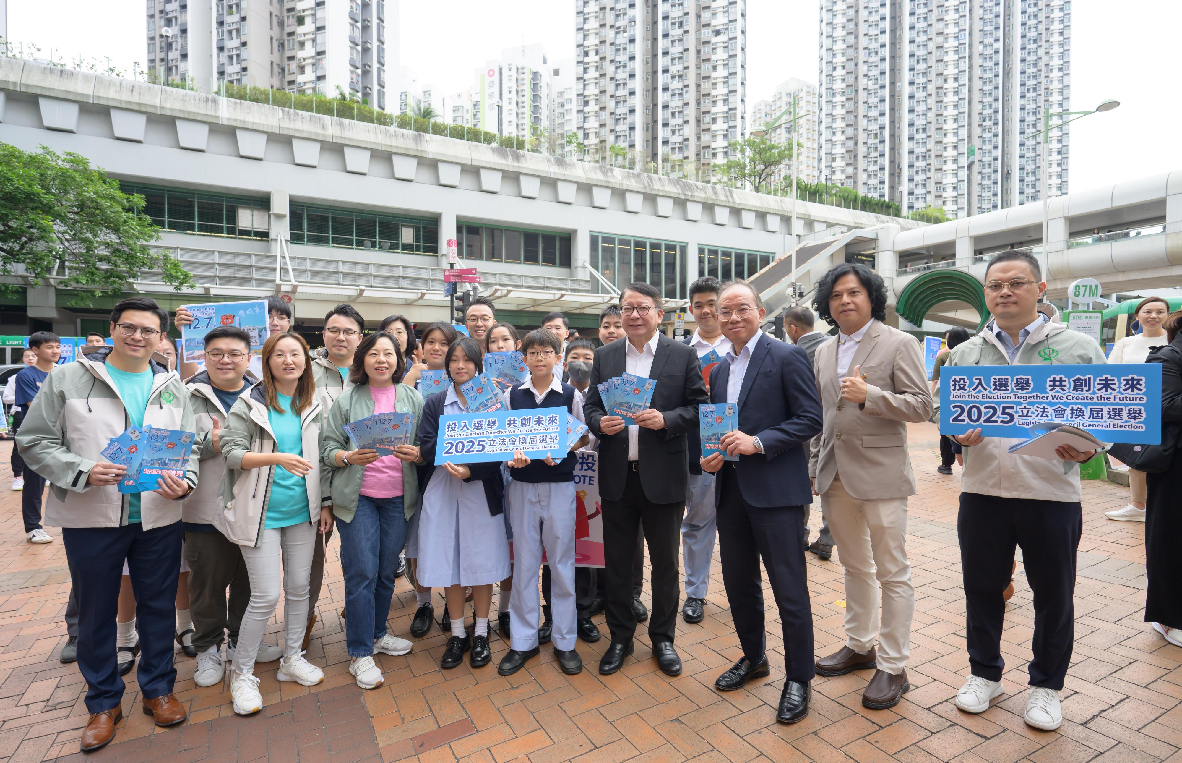 政務司司長陳國基今日（十一月一日）聯同政制及內地事務局局長曾國衞和民政及青年事務局局長麥美娟落區宣傳二○二五年立法會換屆選舉，在葵芳港鐵站外的宣傳街站，呼籲市民於十二月七日投票日踴躍投票。圖示陳國基（前排右四）、曾國衞（前排右三）、麥美娟（前排左三）與街站義工合照。