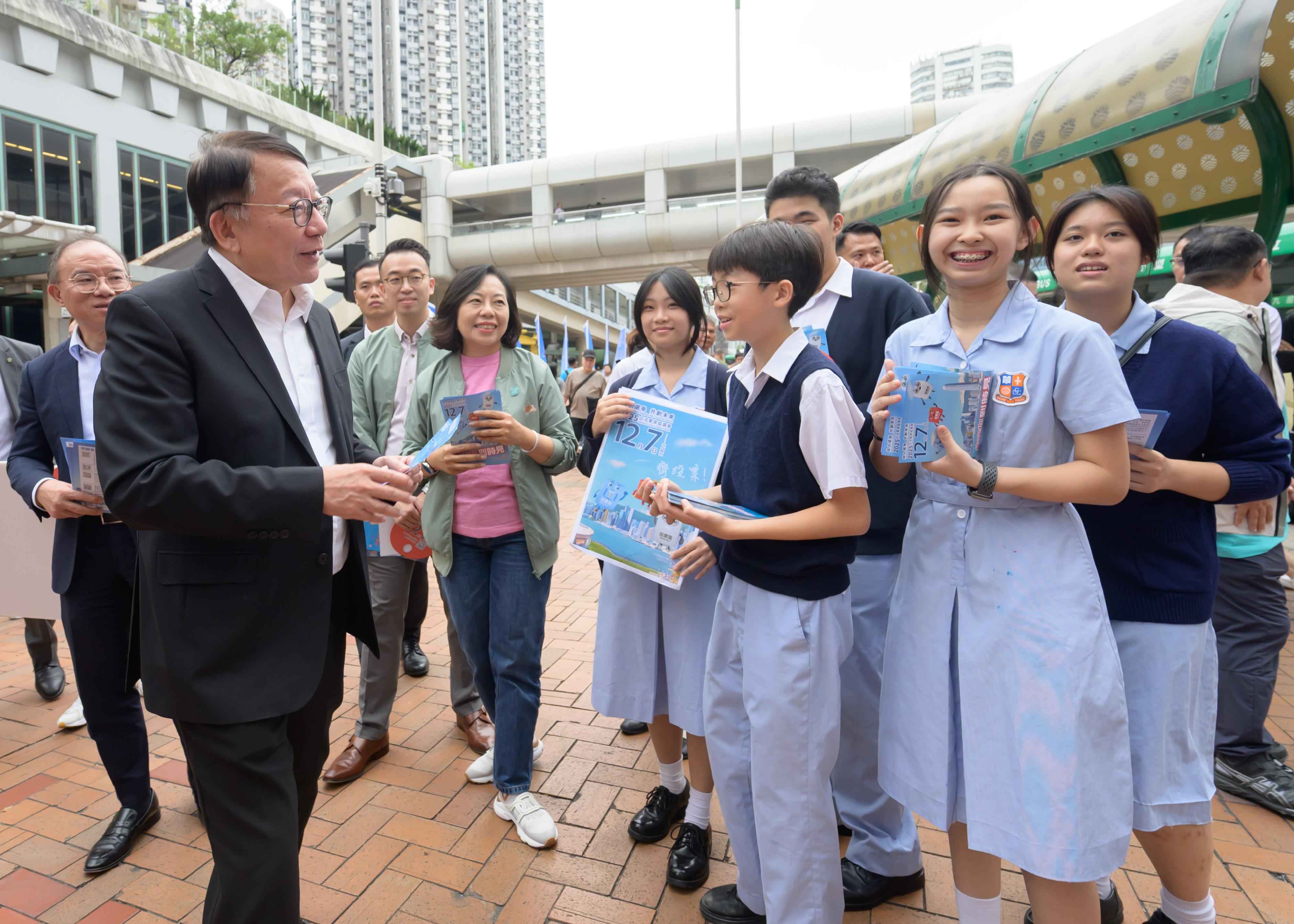 政務司司長陳國基今日（十一月一日）聯同政制及內地事務局局長曾國衞和民政及青年事務局局長麥美娟落區宣傳二○二五年立法會換屆選舉，在葵芳港鐵站外的宣傳街站，呼籲市民於十二月七日投票日踴躍投票。圖示陳國基（左二）在曾國衞（左一）和麥美娟（左五）陪同下，與參與宣傳的學生交談。