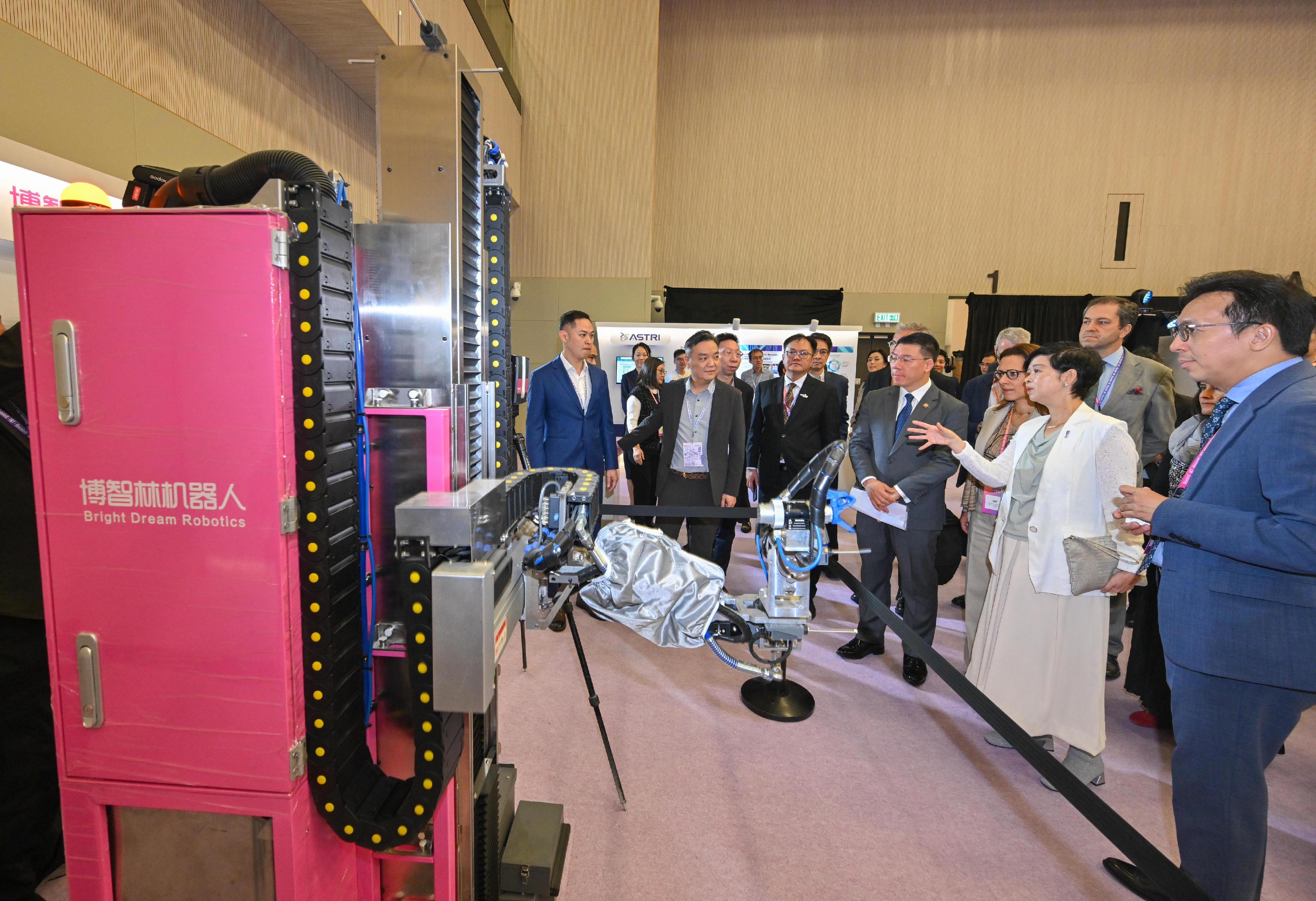 房屋局局長何永賢今日(十一月四日)出席房屋局與香港房屋委員會舉辦的「共築.智能峰會」。圖示何永賢(右二)與其他嘉賓參觀會場內的機械人展示區,並和與會人士互動交流。