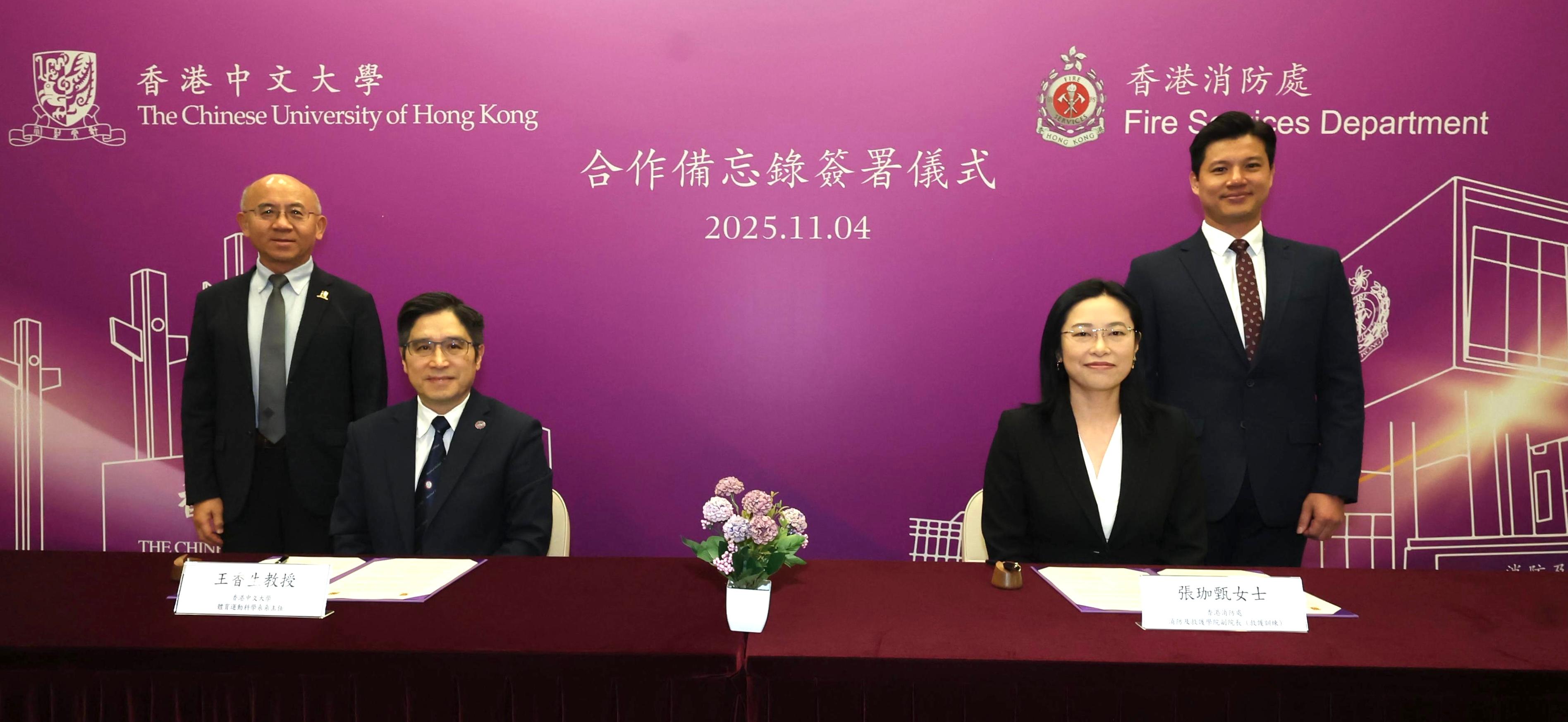 消防及救護學院副院長(救護訓練)張珈甄(右二)今日(十一月四日)和香港中文大學(中大)體育運動科學系主任王香生教授(左二)簽署合作備忘錄,由消防及救護學院與中大的體育運動科學系和賽馬會公共衞生及基層醫療學院合作,共同舉辦有關緊急護理及應急準備的培訓課程。消防及救護學院院長趙汝珏(右一)和中大教育學院院長范息濤教授(左一)亦在場見證簽署儀式。