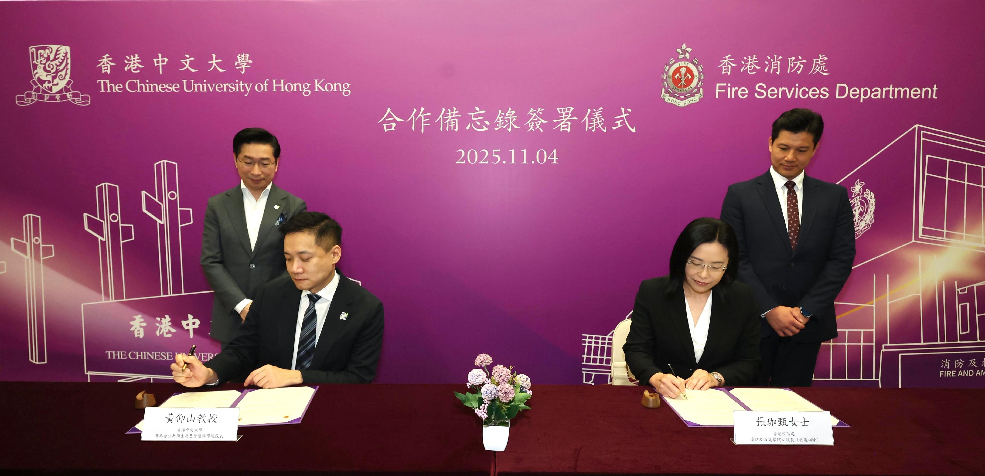 消防及救護學院副院長(救護訓練)張珈甄(右二)今日(十一月四日)和香港中文大學(中大)賽馬會公共衞生及基層醫療學院院長黃仰山教授(左二)簽署合作備忘錄,由消防及救護學院與中大的體育運動科學系和賽馬會公共衞生及基層醫療學院合作,共同舉辦有關緊急護理及應急準備的培訓課程。消防及救護學院院長趙汝珏(右一)和中大醫學院院長趙偉仁教授(左一)亦在場見證簽署儀式。