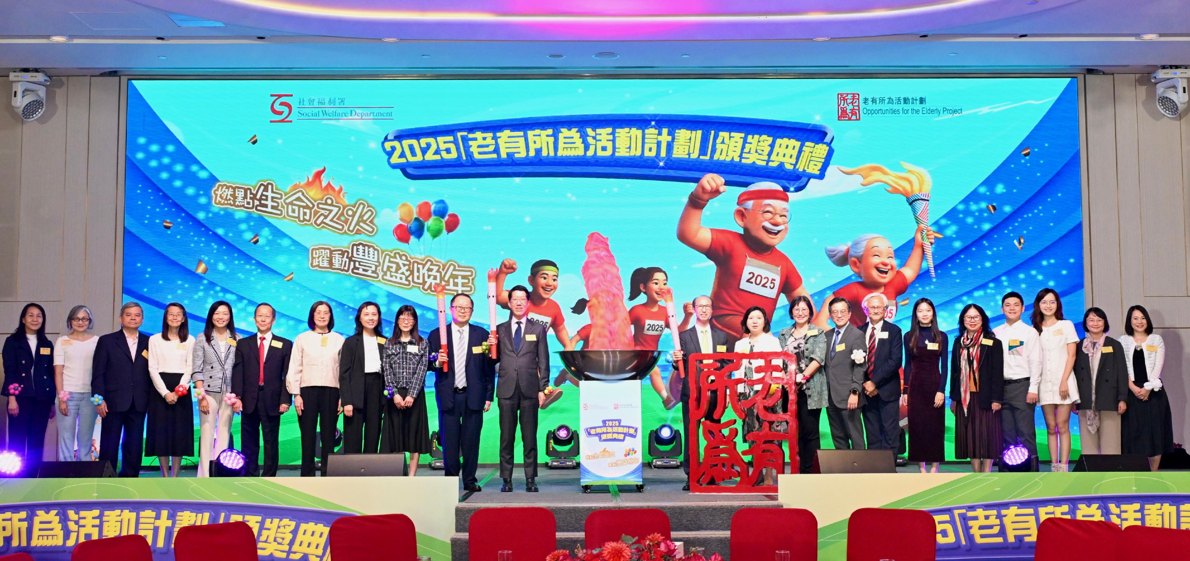 社會福利署(社署)今日(十一月五日)舉辦2025「老有所為活動計劃」頒獎典禮。圖示社署署長杜永恒(左十一)、安老事務委員會主席李國棟醫生(左十)和「老有所為活動計劃」諮詢委員會主席潘廣輝(右十一),聯同其他嘉賓與「老友記」同迎第十五屆全國運動會。