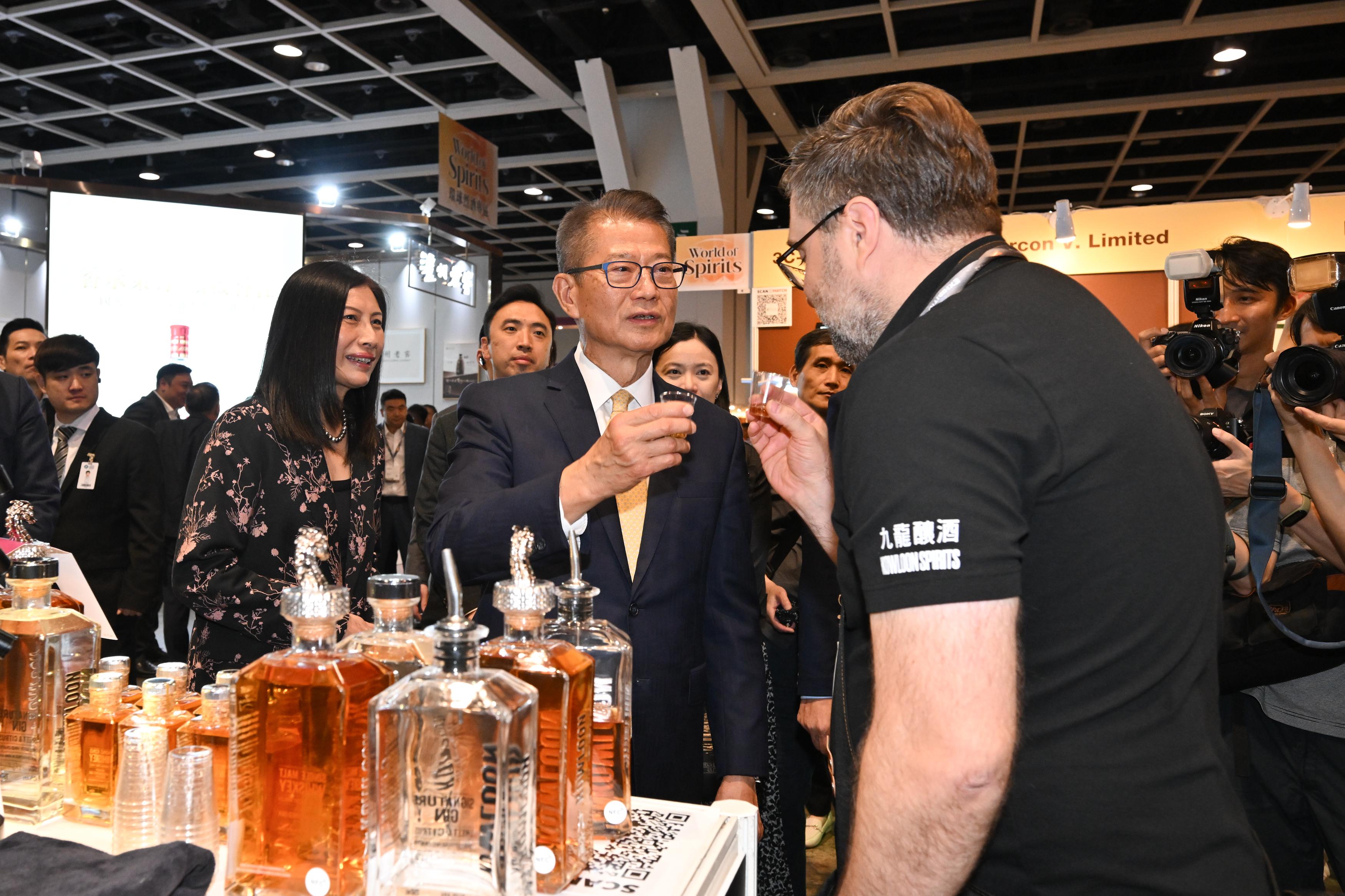 The Financial Secretary, Mr Paul Chan, attended the Hong Kong International Wine and Spirits Fair 2025 today (November 6). Photo shows Mr Chan (centre) visiting an exhibition booth. Looking on is the Acting Executive Director of the Hong Kong Trade Development Council, Ms Jenny Koo (first left).