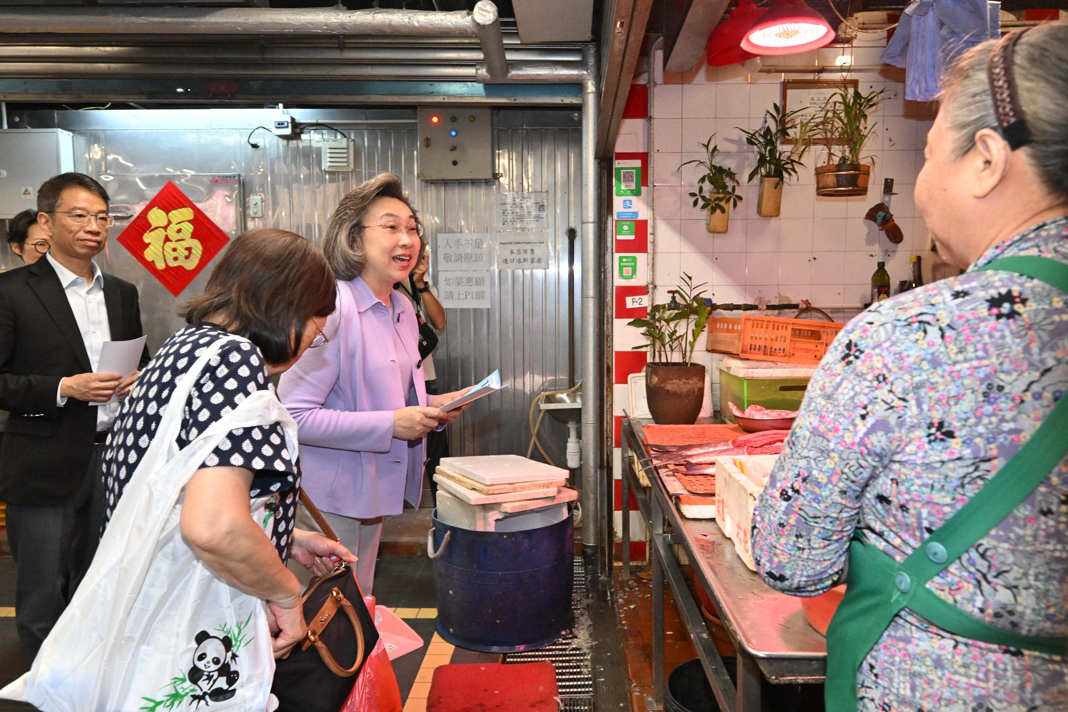 公務員事務局局長楊何蓓茵今日(十一月十日)率領局內高層人員到駱克道市政大廈,向部門派駐分區辦事處和場地的前線公務員宣傳十二月七日立法會選舉,號召同事踴躍投票、支持選舉。圖示楊何蓓茵(左三)向市政大廈街市商販宣傳立法會選舉。旁為公務員事務局常任秘書長梁卓文(左一)。