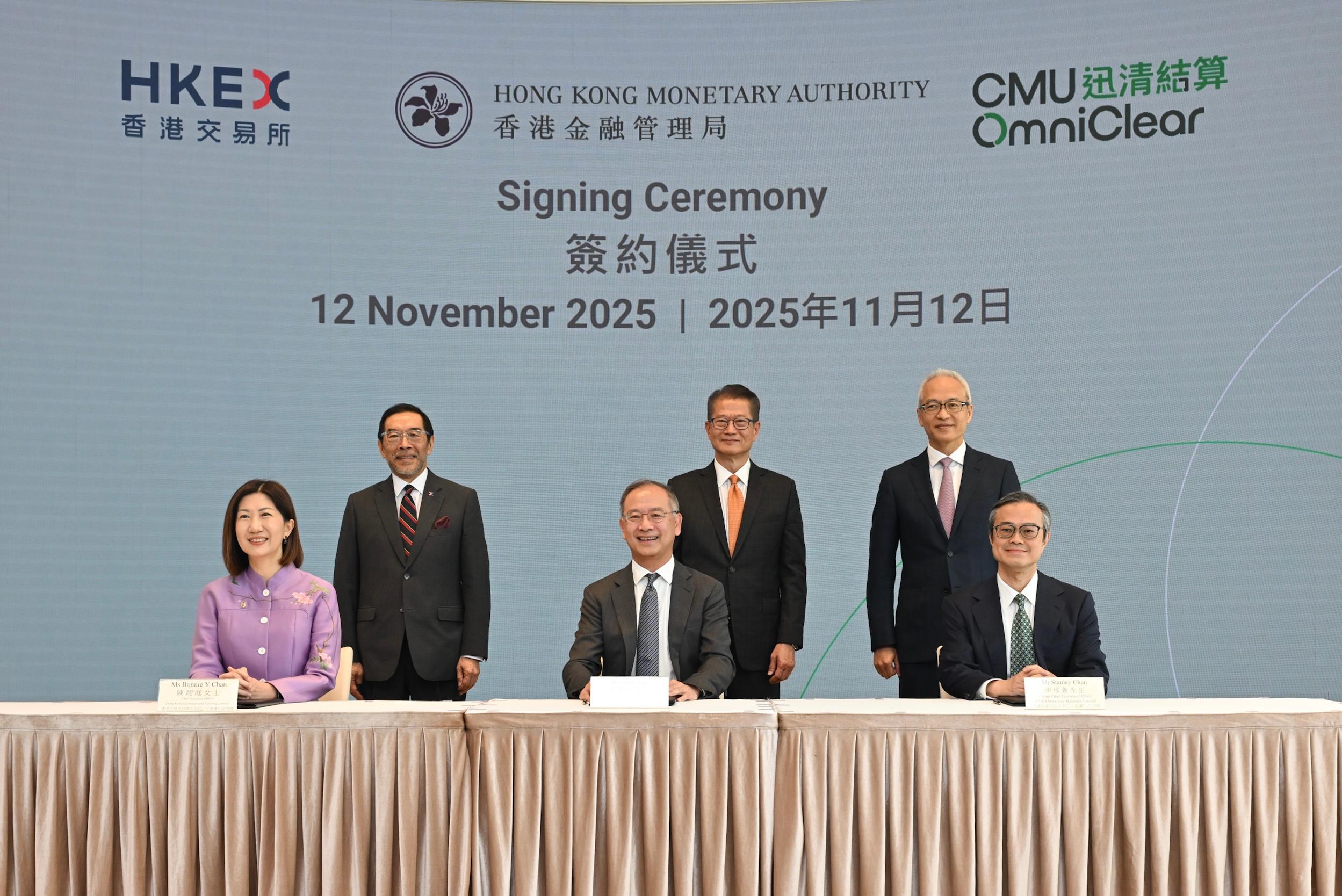 財政司司長陳茂波今日（十一月十二日）出席香港金融管理局（金管局）、香港交易及結算所有限公司（香港交易所）及迅清結算控股有限公司簽約儀式。圖示（後排左起）香港交易所主席唐家成、陳茂波和金管局副總裁及迅清結算控股副主席李達志見證（前排左起）香港交易所集團行政總裁陳翊庭、金管局總裁及迅清結算控股主席余偉文和迅清結算控股集團行政總裁陳達強簽約。