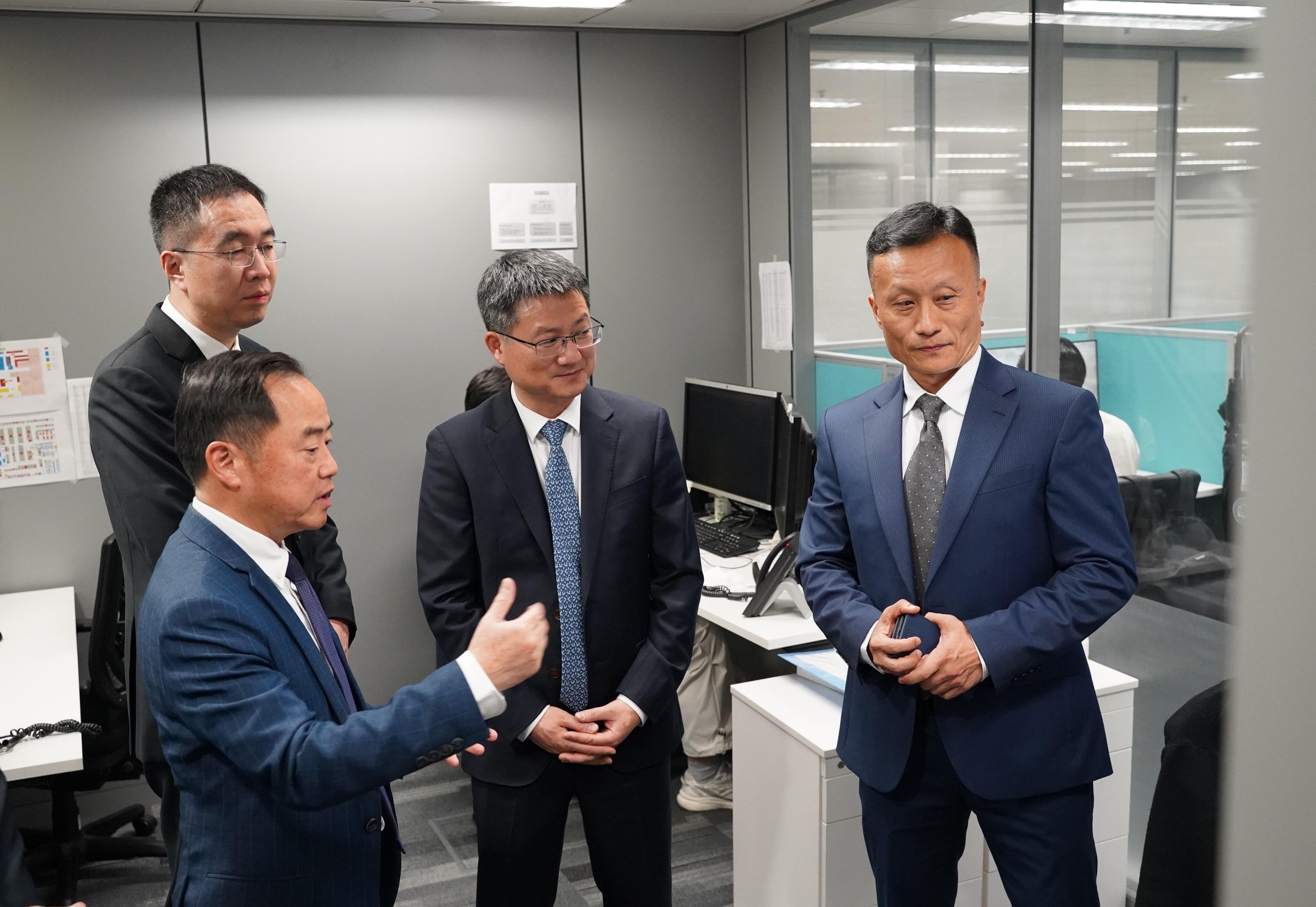 數字政策專員黃志光（左一）十一月十一日向北京市政務服務和數據管理局代表團講解1823聯絡中心的日常運作及創新科技的應用。