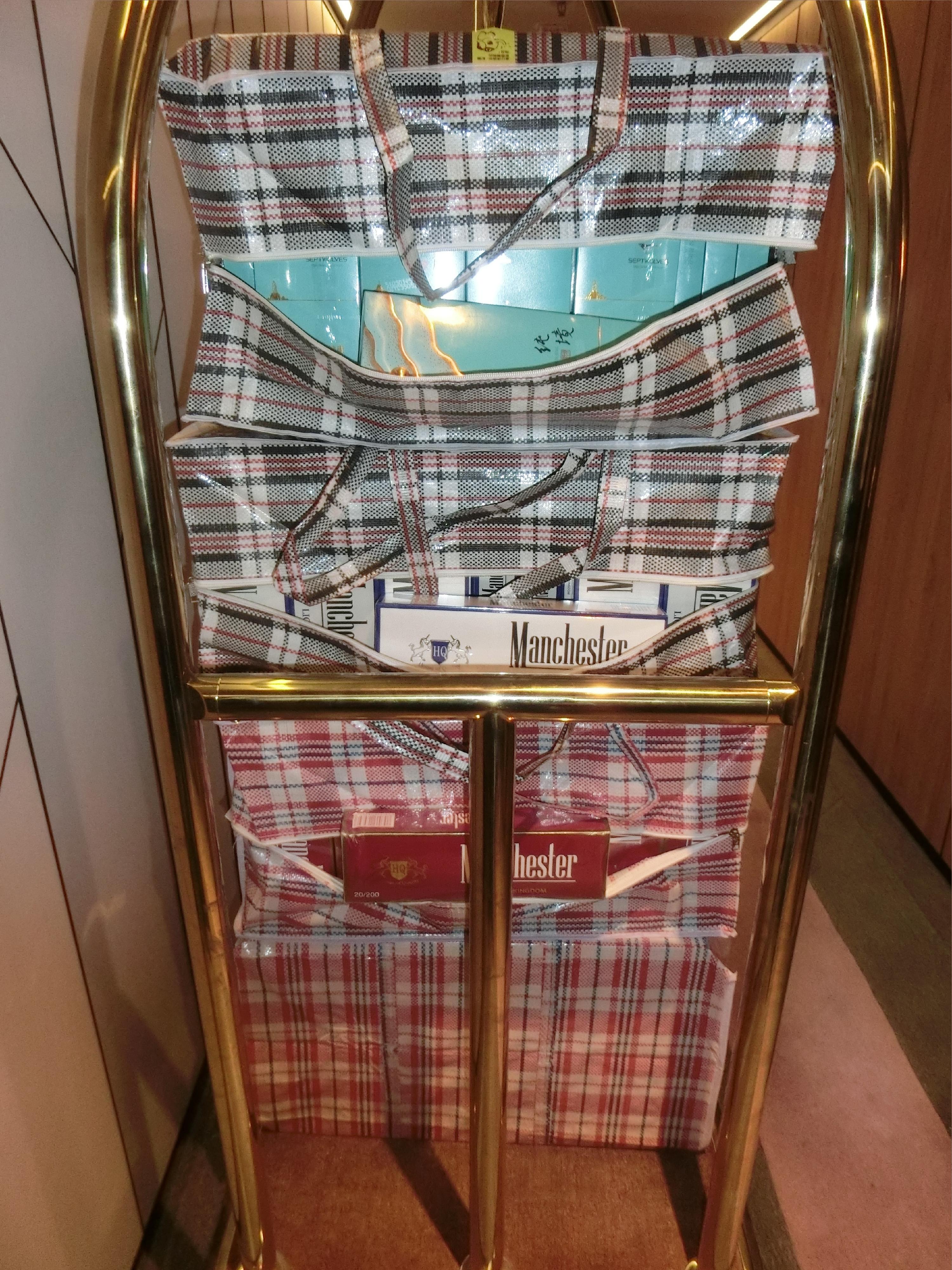 香港海關昨日（十一月十二日）在葵涌搗破一個懷疑私煙貯存倉庫，檢獲約二十四萬支懷疑私煙，估計市值約一百零八萬元，應課稅值約七十九萬元，並拘捕五名懷疑涉案人士。圖示在酒店行李車上檢獲的部分懷疑私煙。