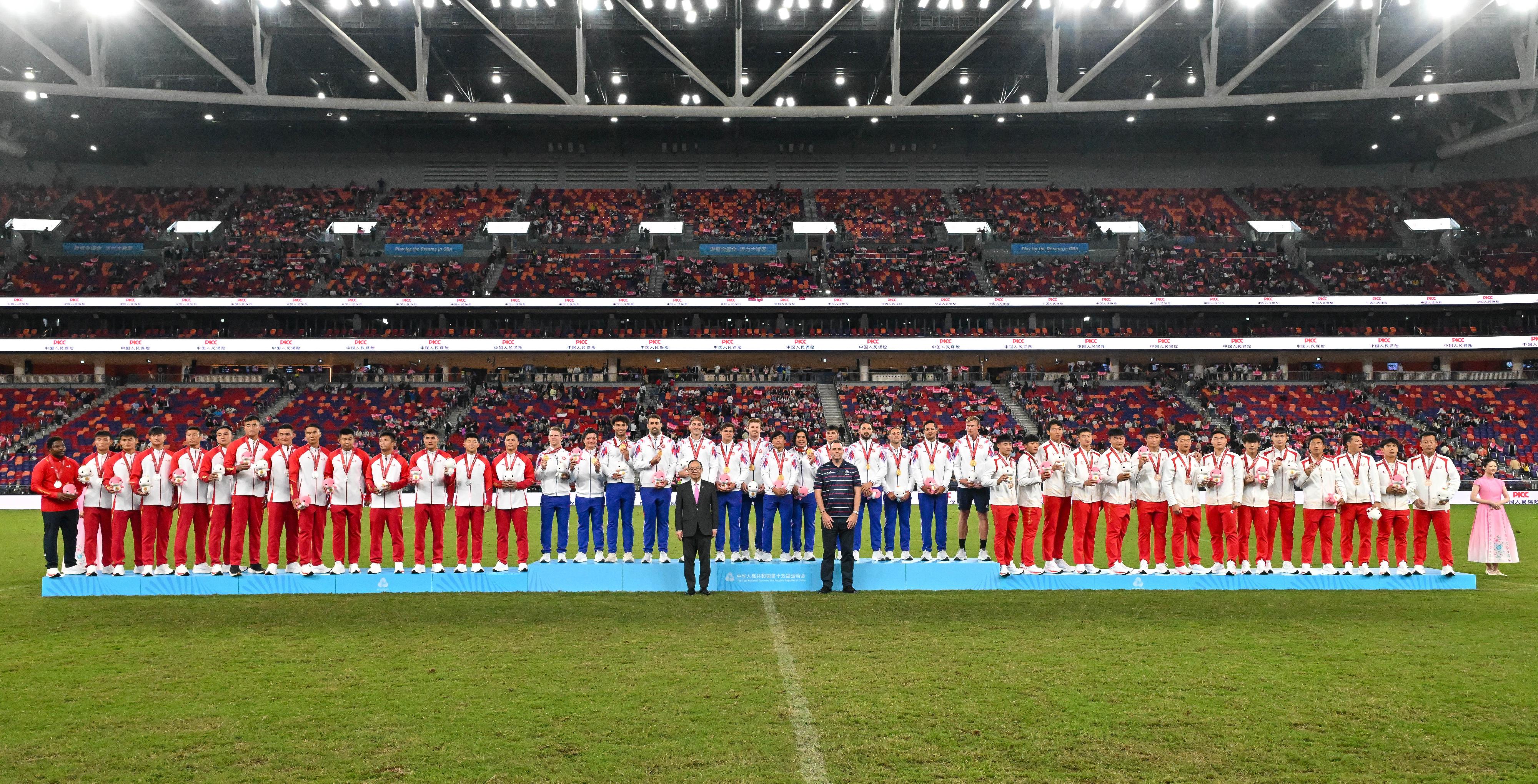The 15th National Games of the People's Republic of China The Hong Kong Jockey Club Trophy Men's Rugby Sevens Competition was held today (November 14). Photo shows the Chairman of the Hong Kong China Rugby Union, Mr Chris Brooke (front row, right), and the Chairman of the Hong Kong Jockey Club, Mr Martin Liao (front row, left), with the gold medalists, Hong Kong team (back row, centre); the silver medalists, Shandong team (back row, left); and the bronze medalists, Beijing team (back row, right).
