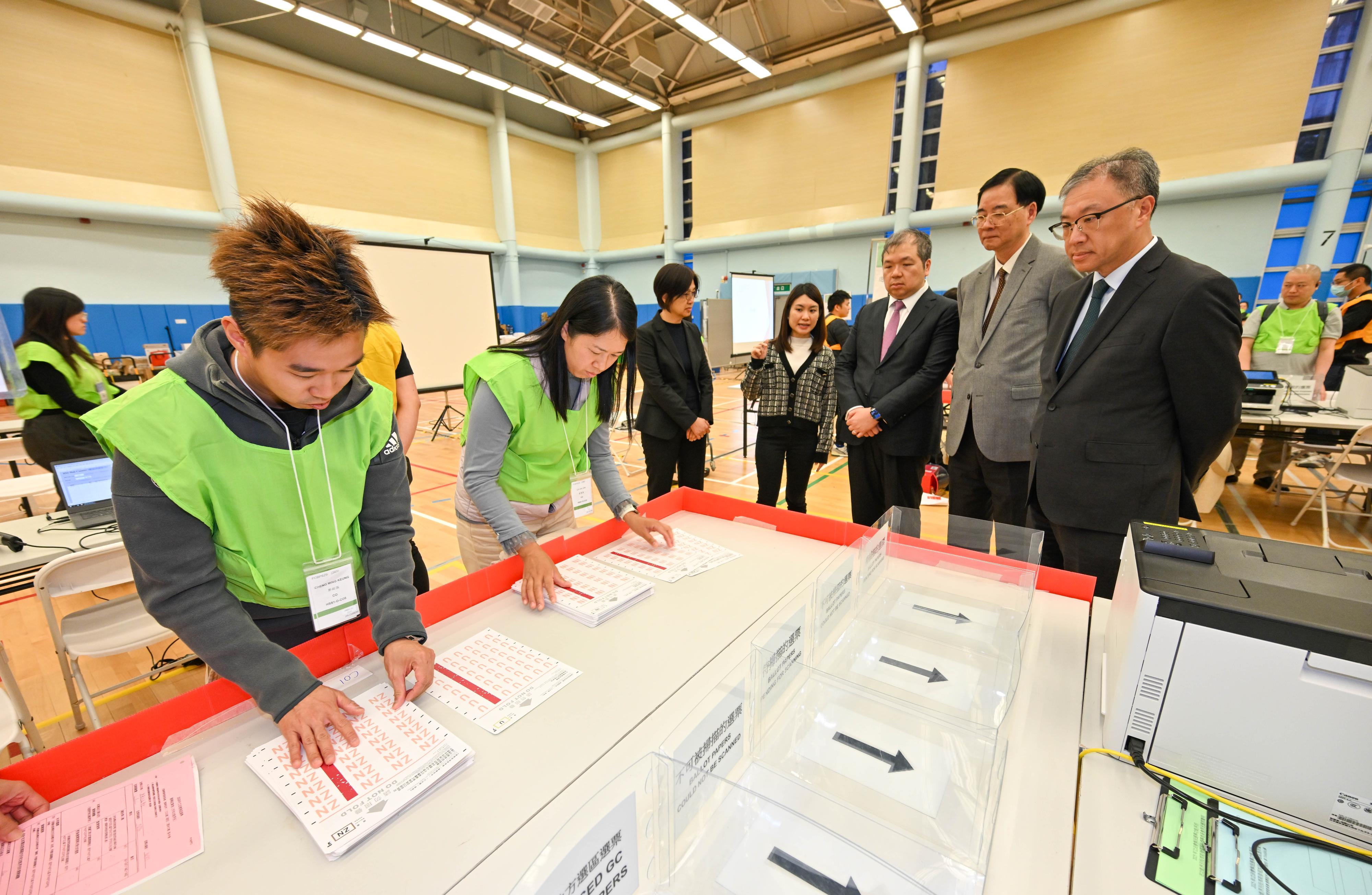 二○二五年立法會換屆選舉將於十二月七日(星期日)舉行。選舉事務處過去數星期為負責不同崗位的選舉工作人員舉辦多場簡介會和實習訓練,加深他們對發票及點票程序和各項細節的了解。選舉管理委員會(選管會)主席陸啟康法官(右一)今日(十一月十九日)視察選舉事務處為投票日在中央點票站點算功能界別選票的工作人員而設的培訓。旁為選管會委員石丹理教授(右二)和文本立資深大律師(右三)。