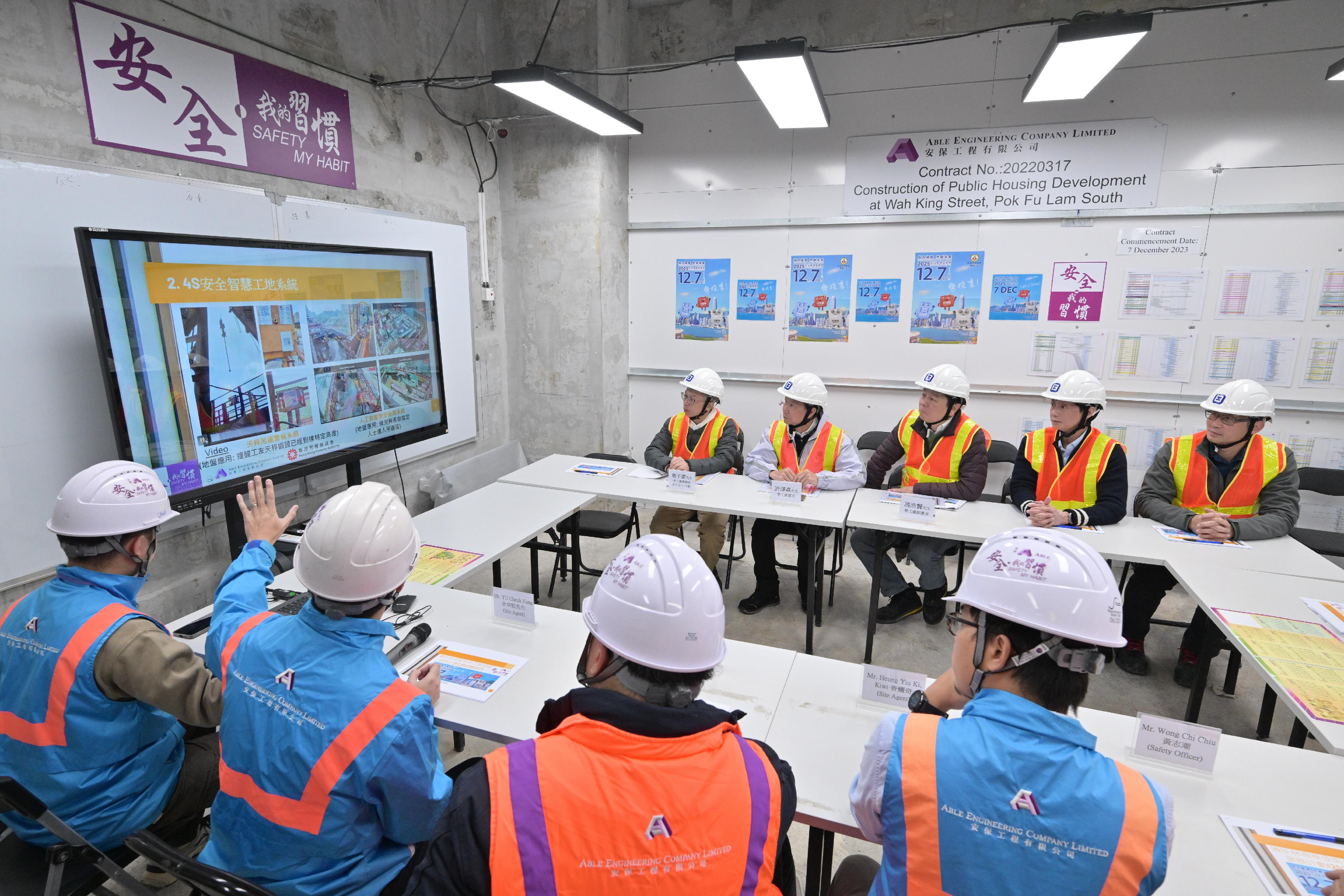 The Commissioner for Labour, Mr Sam Hui, and the Deputy Commissioner for Labour (Occupational Safety and Health), Mr Vincent Fung, visited a construction site in Southern District today (November 20). Photo shows representatives of the contractor briefing Mr Hui (back row, second left) and Mr Fung (back row, centre) on various occupational safety and health measures at the site.