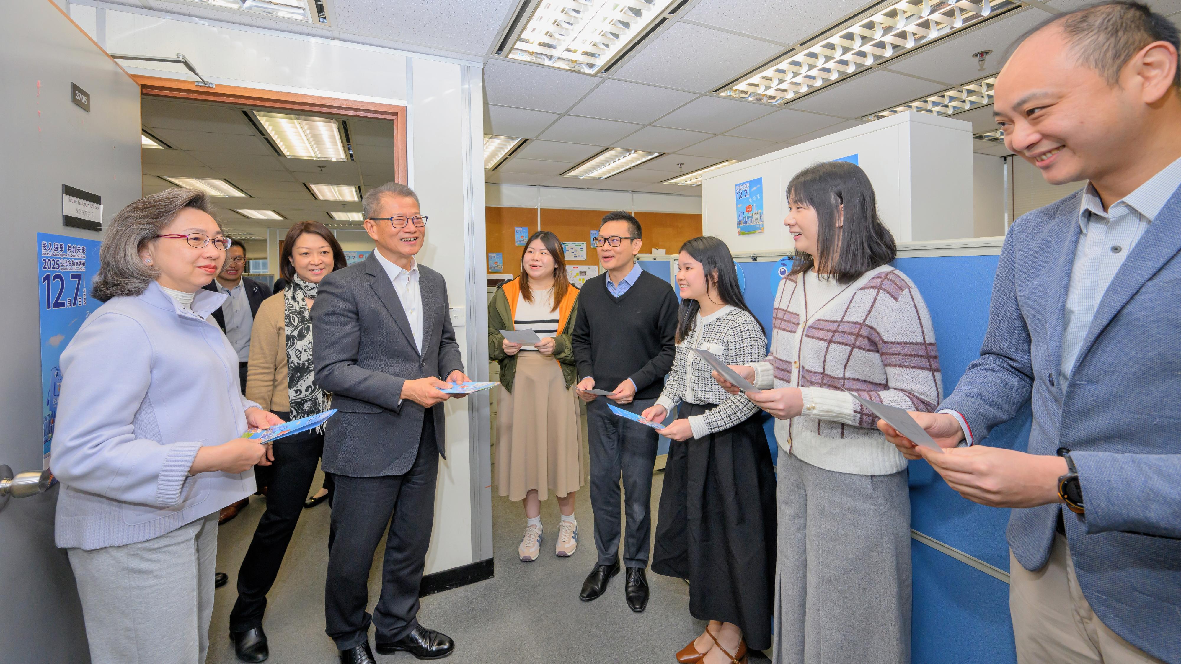 The Financial Secretary, Mr Paul Chan; the Secretary for Justice, Mr Paul Lam, SC; and the Secretary for the Civil Service, Mrs Ingrid Yeung, visited government offices in Wan Chai today (November 20) to promote and call on civil servants to vote together in the Legislative Council (LegCo) Election on December 7. Photo shows Mr Chan (third right) and Mrs Yeung (first left) reminding colleagues at the workplace of the Transport Department to vote with their families in the LegCo Election on December 7. Looking on is the Commissioner for Transport, Ms Angela Lee (second left).