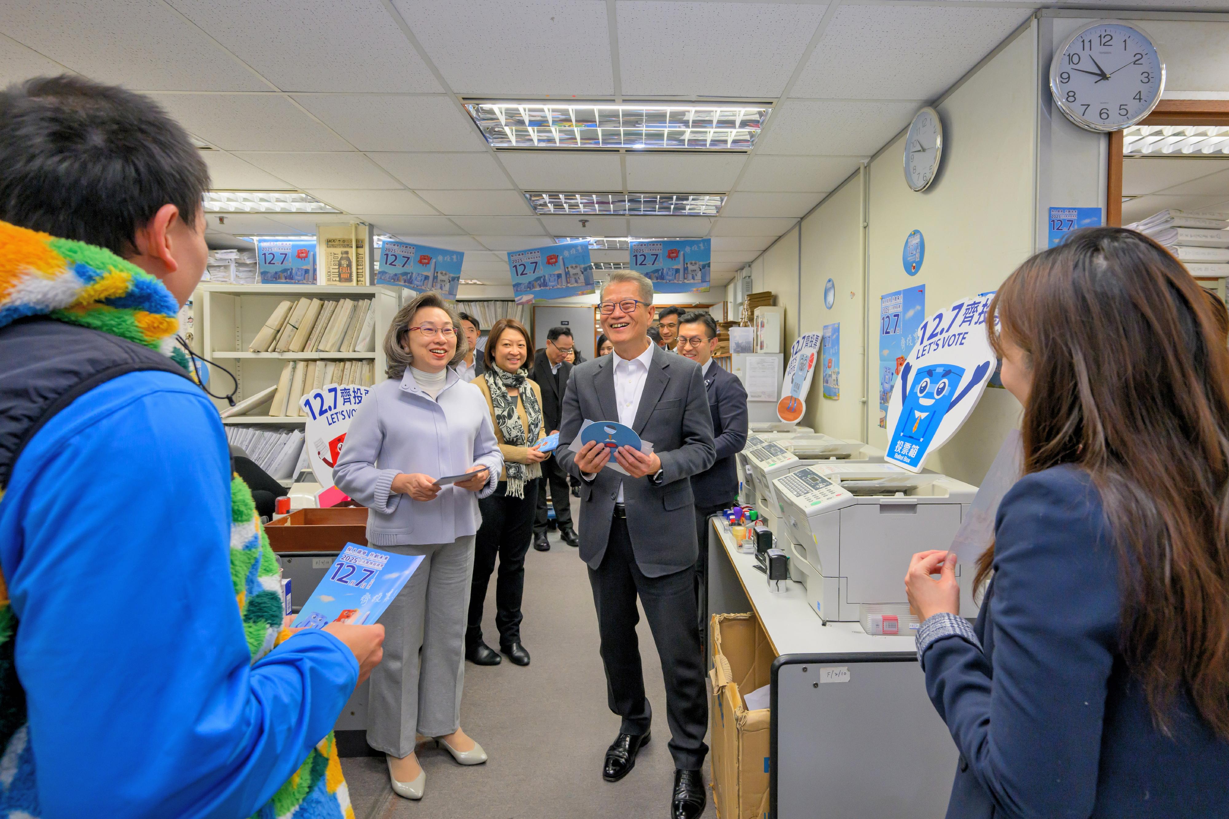 The Financial Secretary, Mr Paul Chan; the Secretary for Justice, Mr Paul Lam, SC; and the Secretary for the Civil Service, Mrs Ingrid Yeung, visited government offices in Wan Chai today (November 20) to promote and call on civil servants to vote together in the Legislative Council (LegCo) Election on December 7. Photo shows Mr Chan (right) and Mrs Yeung (left) reminding colleagues at the workplace of the Transport Department to vote with their families in the LegCo Election on December 7.