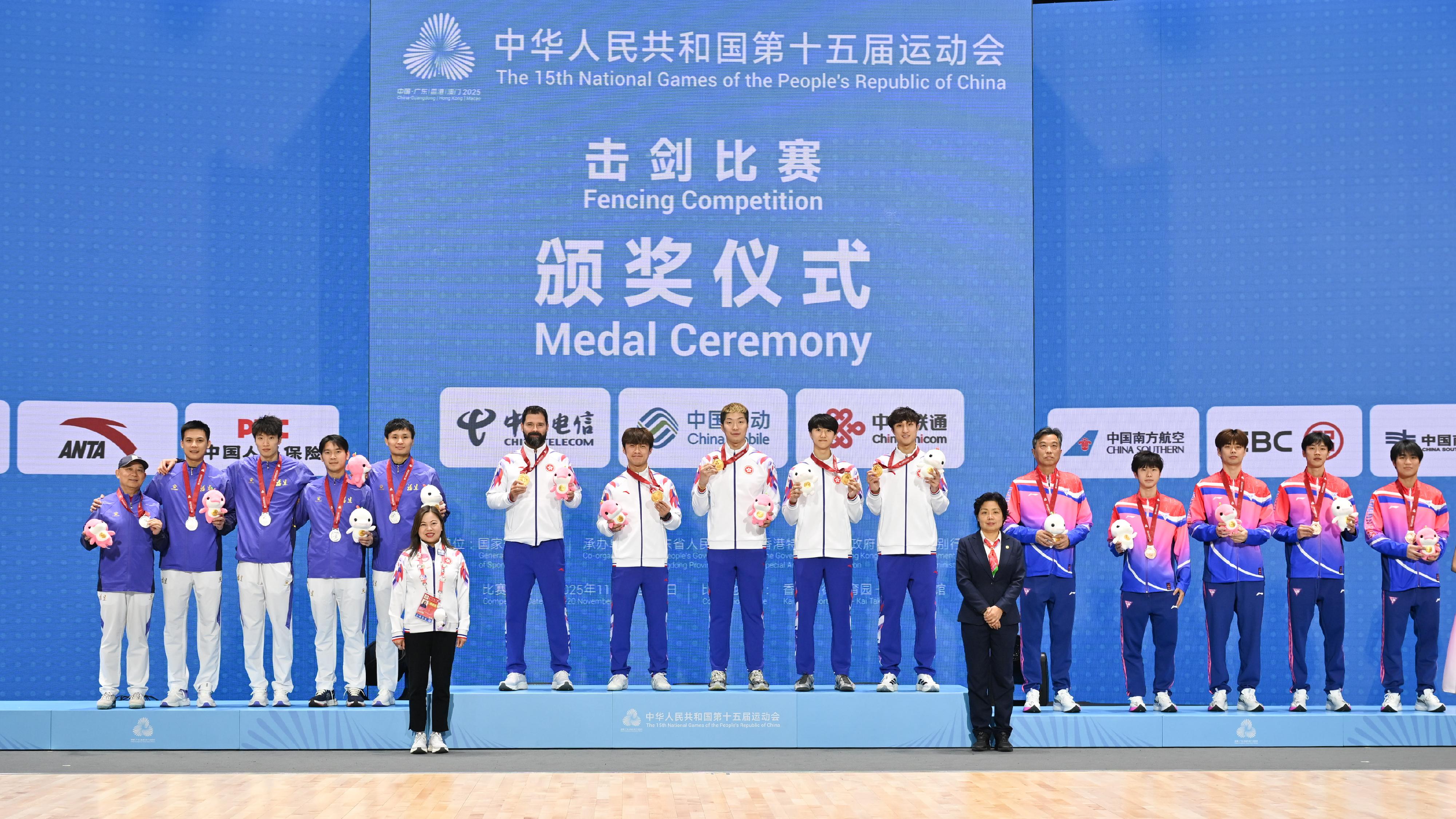 The Men's Foil Team of the fencing competition of the 15th National Games was held today (November 19). Photo shows the Secretary for Culture, Sports and Tourism, Miss Rosanna Law (front row, left), and the vice director of the cycling and fencing sports management centre of the General Administration of Sport of China and the vice president and secretary-general of the Chinese Fencing Association, Ms Wang Junyan (front row, right), with the gold medalists, Hong Kong Team (back row, centre), the silver medalists, Fujian Team (back row, left), and the bronze medalists, Shanghai Team (back row, right).