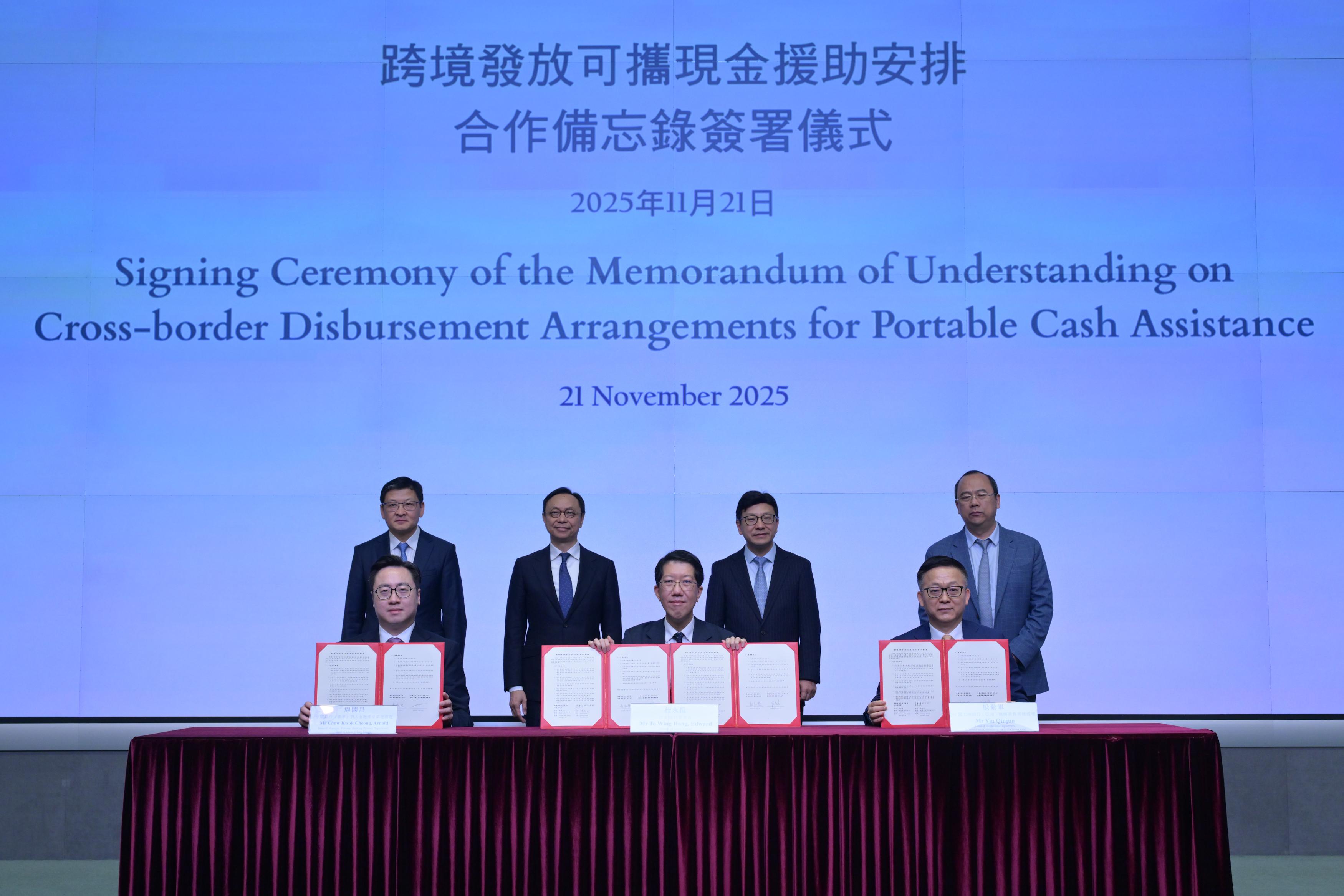 The Social Welfare Department signed today (November 21) Memoranda of Understanding (MOU) with the Bank of China (Hong Kong) (BOCHK), and the Industrial and Commercial Bank of China (Asia) (ICBC (Asia)) respectively, to take forward cross-border disbursement arrangements for portable cash assistance. Photo shows the Secretary for Labour and Welfare, Mr Chris Sun (back row, second right); Deputy Chief Executive of the Hong Kong Monetary Authority Mr Darryl Chan (back row, second left); the Vice Chairman and Chief Executive of the BOCHK, Mr Sun Yu (back row, first left); and the Chairman and Executive Director of the ICBC (Asia), Dr Liu Yagan (back row, first right), witnessing the Director of Social Welfare, Mr Edward To (front row, centre), signing the MOU with the General Manager, Personal Banking Product Department of the BOCHK, Mr Arnold Chow (front row, left), and the Head of Institutions Department of the ICBC (Asia), Mr Yin Qinjun (front row, right), respectively.