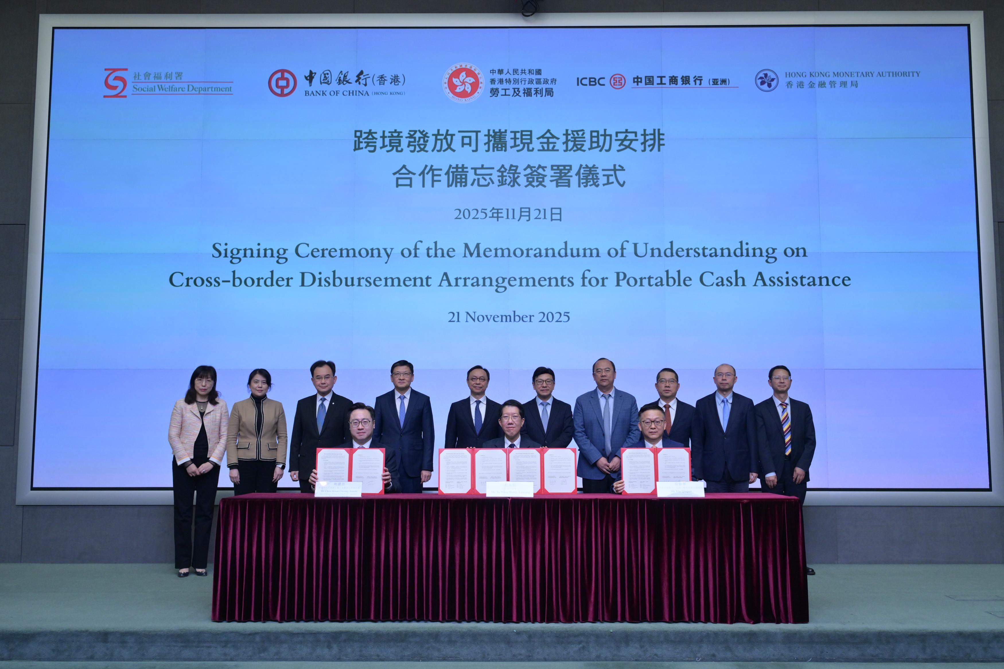 The Social Welfare Department signed today (November 21) Memoranda of Understanding (MOU) with the Bank of China (Hong Kong) (BOCHK) and the Industrial and Commercial Bank of China (Asia) (ICBC (Asia)) respectively, to take forward cross-border disbursement arrangements for portable cash assistance. Photo shows the Secretary for Labour and Welfare, Mr Chris Sun (back row, fifth right); Deputy Chief Executive of the Hong Kong Monetary Authority Mr Darryl Chan (back row, fifth left); the Vice Chairman and Chief Executive of the BOCHK, Mr Sun Yu (back row, fourth left); the Chairman and Executive Director of the ICBC (Asia), Dr Liu Yagan (back row, fourth right); the Director of Social Welfare, Mr Edward To (front row, centre); the General Manager, Personal Banking Product Department of the BOCHK, Mr Arnold Chow (front row, left); and the Head of Institutions Department of the ICBC (Asia), Mr Yin Qinjun (front row, right), with senior representatives of both banks at the signing ceremony.