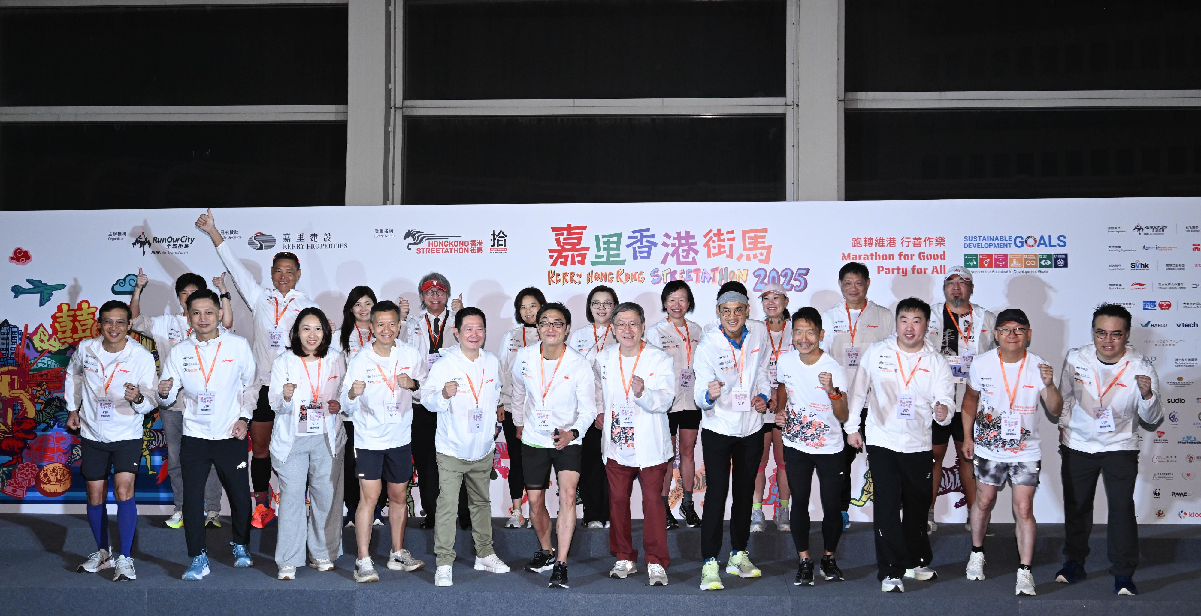 政務司副司長卓永興今日（十一月二十三日）與一眾嘉賓主持「嘉里香港街馬2025」全馬賽事起步禮。圖示（前排左五起）海濱事務委員會主席何文堯、「全城街馬」基金會董事局主席羅君本、卓永興、嘉里控股有限公司董事長郭孔華、「全城街馬」聯合創辦人及行政總裁梁百行博士與一眾嘉賓台上合照。