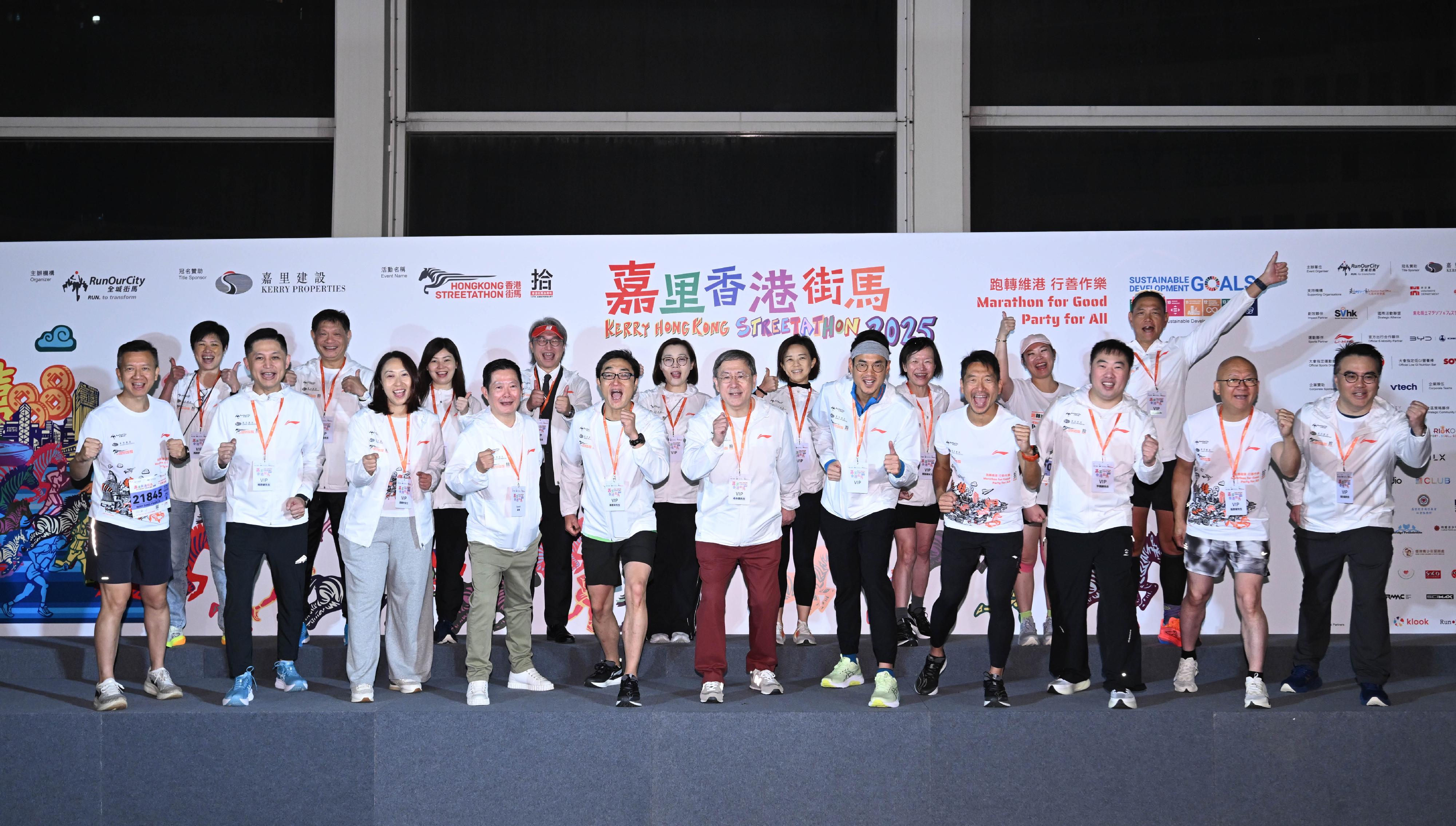 政務司副司長卓永興今日（十一月二十三日）與一眾嘉賓主持「嘉里香港街馬2025」半馬賽事起步禮。圖示（前排左四起）海濱事務委員會主席何文堯、「全城街馬」基金會董事局主席羅君本、卓永興、嘉里控股有限公司董事長郭孔華、「全城街馬」聯合創辦人及行政總裁梁百行博士與一眾嘉賓台上合照。