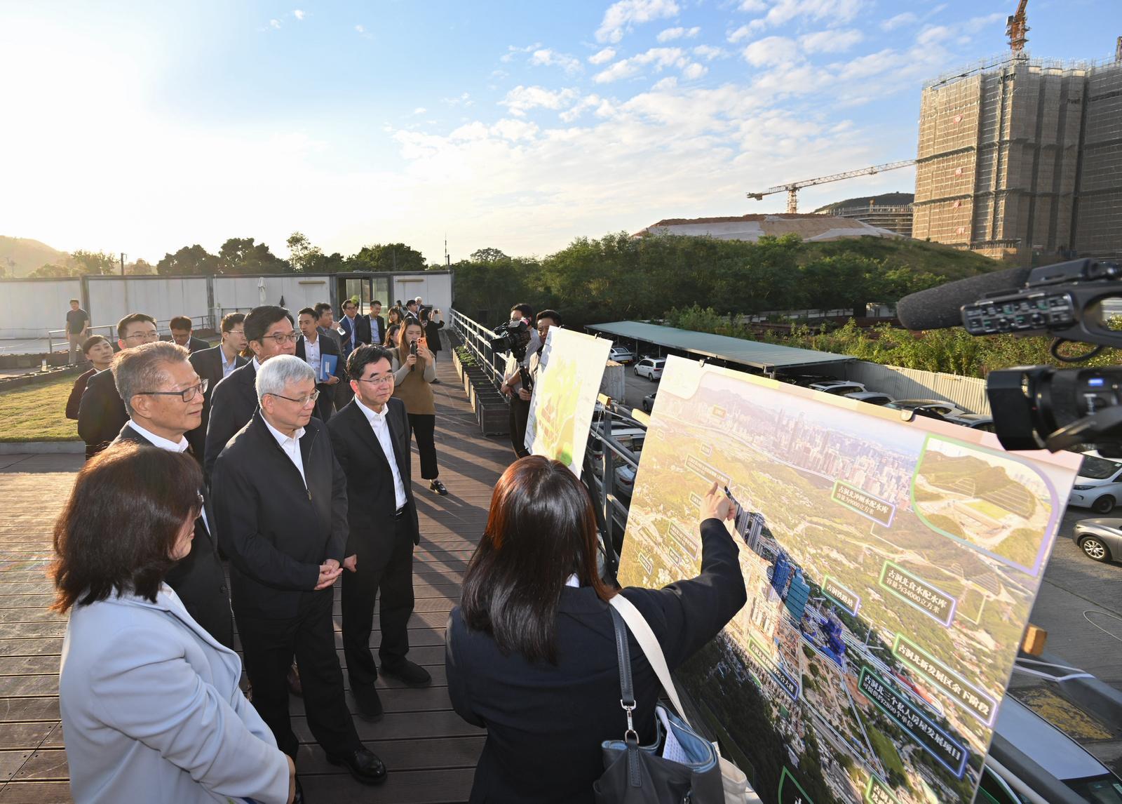 來港宣講中共二十屆四中全會精神的中央宣講團成員，中國科學院院長、黨組書記侯建國，以及中央財經委員會辦公室副主任、中央農村工作領導小組辦公室副主任祝衛東今日（十一月二十四日）下午在香港特別行政區政府財政司司長陳茂波陪同下，到北部都會區調研交流。圖示侯建國（左三）、祝衛東（左五）、陳茂波（左二）、財政司副司長黃偉綸（左四）和發展局局長甯漢豪（左一）到訪古洞北新發展區地盤辦公樓，了解新發展區的規劃及建設情況。