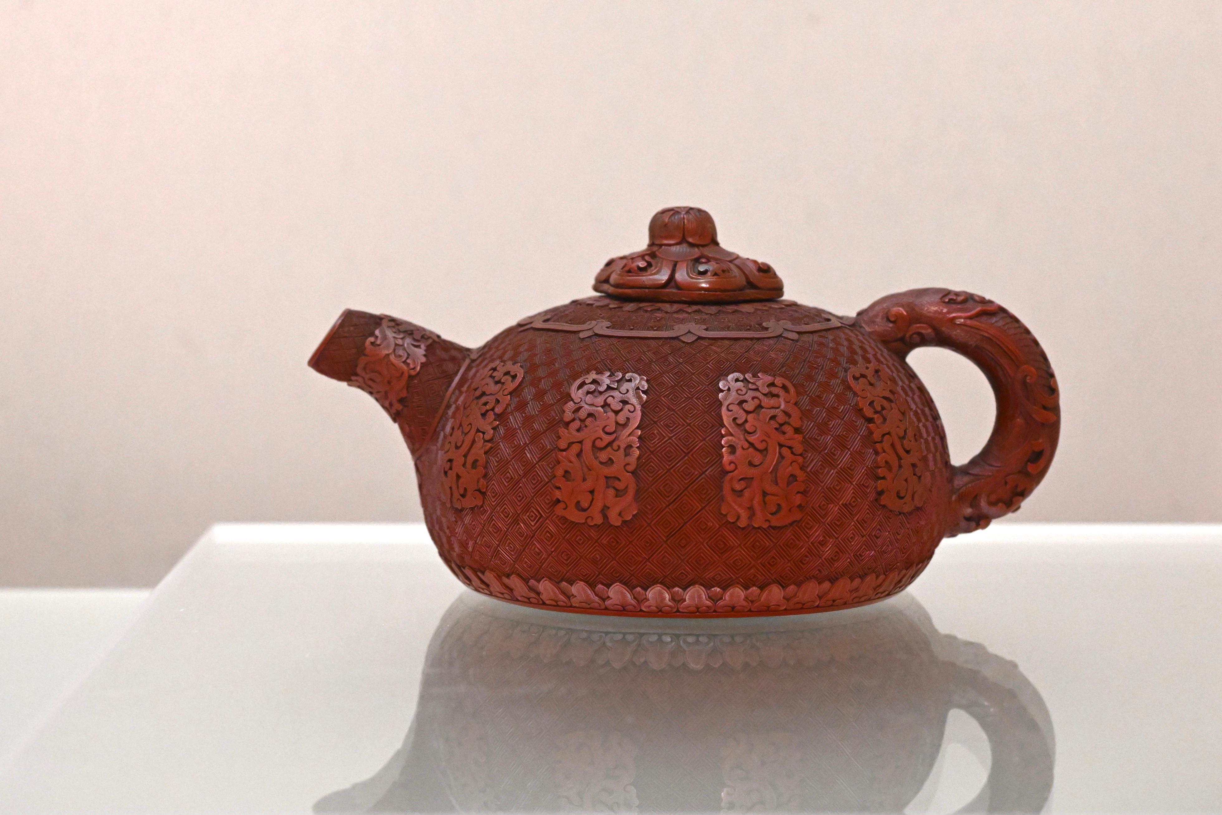The Flagstaff House Museum of Tea Ware will stage the "Hong Kong Artist Dialogue Series: Shape of Tea" exhibition starting from tomorrow (November 26), featuring 35 sets of tea ware from the museum's collections, along with 20 sets of new works created by wood artist Yan Yung and bamboo artist Inkgo Lam. Photo shows a purple clay teapot encased in carved red lacquer with archaic dragons on diaper ground from the 18th century.