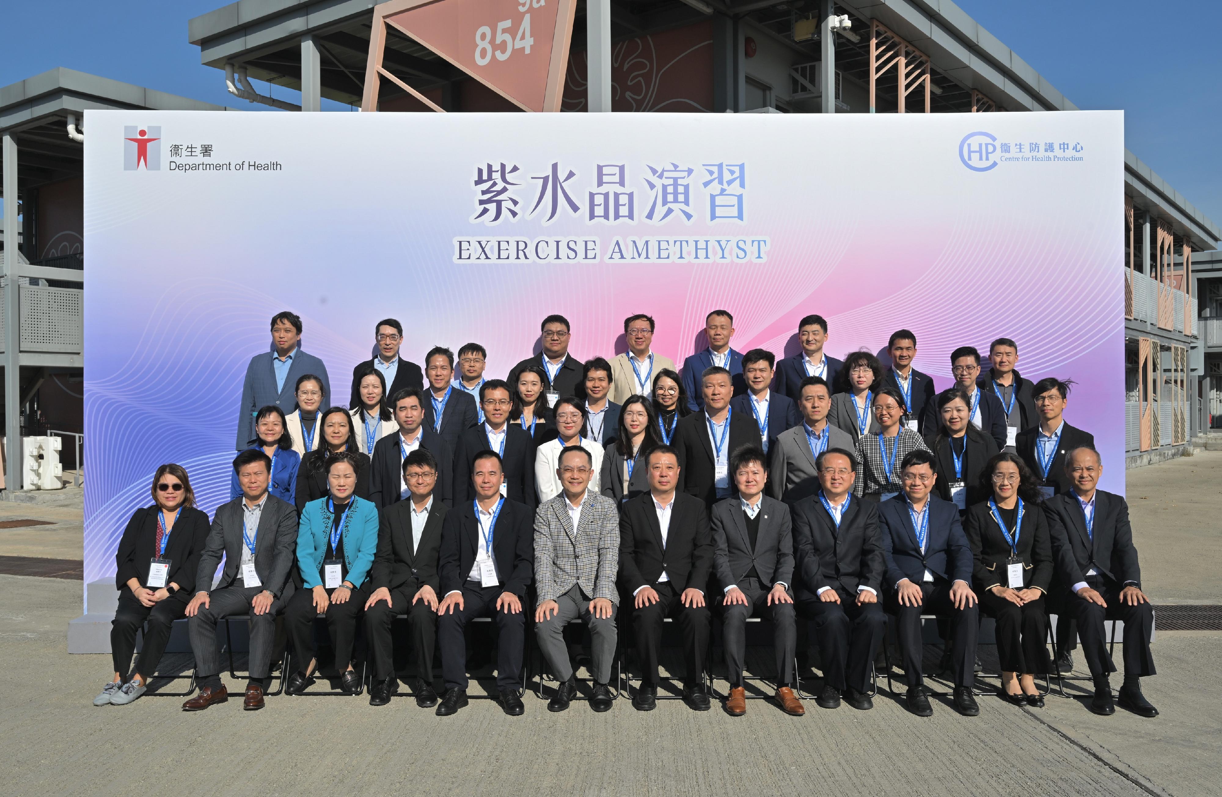 The Centre for Health Protection (CHP) of the Department of Health (DH), in collaboration with multiple government departments, today (November 25) conducted a public health exercise codenamed "Amethyst" to enhance their response capabilities in dealing with a case of Ebola disease, and to increase awareness among stakeholders about the handling of public health emergencies. To strengthen exchanges with the Chinese Mainland and the international community, over 20 experts from the National Health Commission (NHC), the National Disease Control and Prevention Administration, Shaanxi Province, Hubei Province, Guangdong province, Chinese Mainland cities in the Guangdong-Hong Kong-Macao Greater Bay Area, the Macao Special Administrative Region and Singapore health authorities were invited to attend as observers. Photo shows the Director of Health, Dr Ronald Lam (first row, sixth left); the Controller of the CHP of the DH, Dr Edwin Tsui (first row, fifth right); the Deputy Director-General of the Department of Medical Emergency Response of the NHC, Mr Gao Xinqiang (first row, sixth right), and other observers.